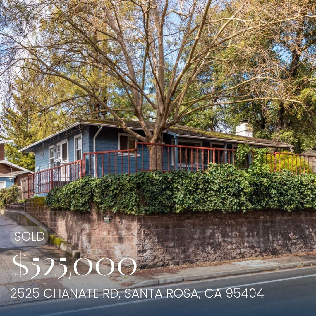 A blue house with a red railing on a raised brick foundation, surrounded by greenery and a large tree in front, with the text indicating the property is under contract for $549,999 at 2525 Chanate Road, Santa Rosa, California.