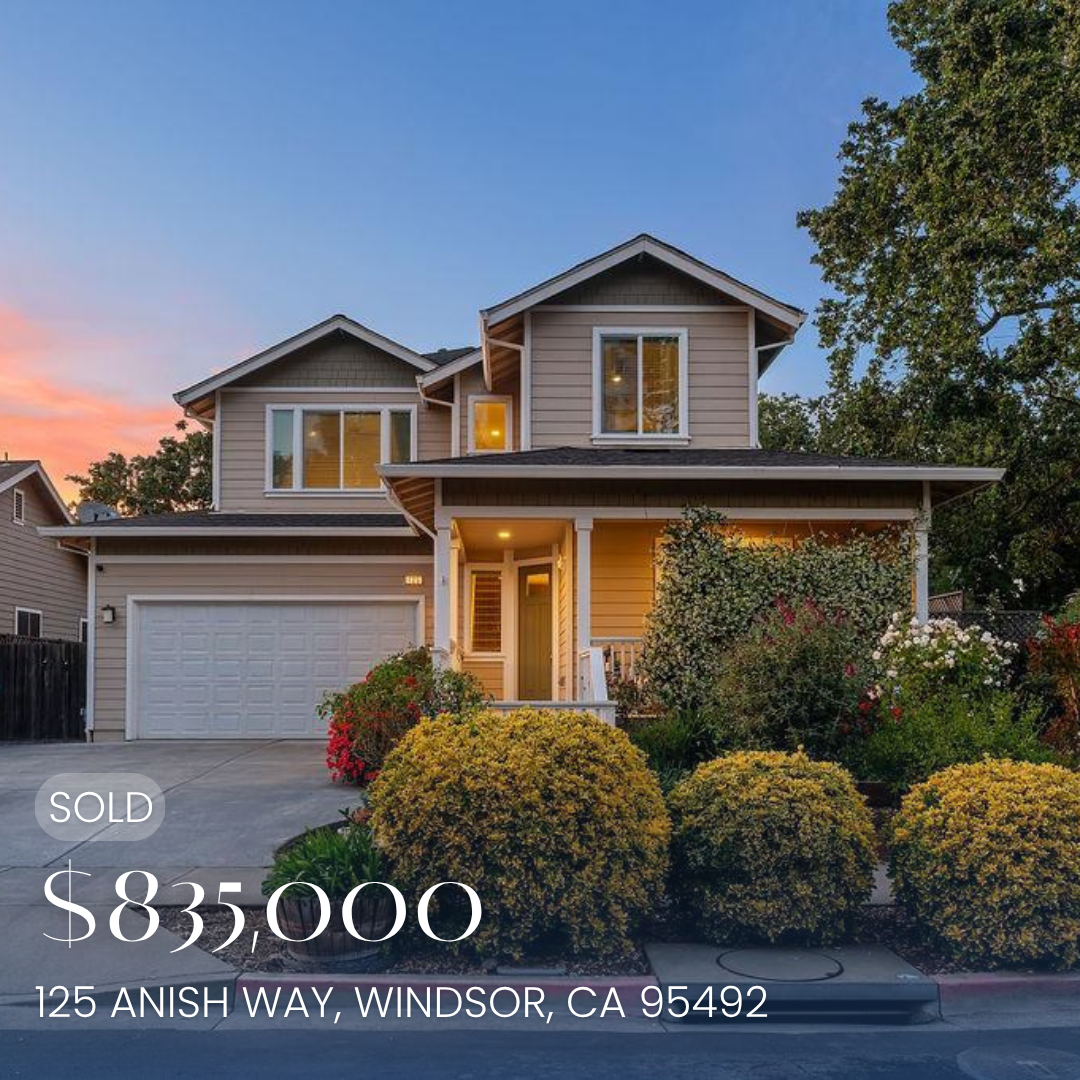 Front view of a two-story house with a beige exterior, white trim, a garage, and a front porch surrounded by bushes and plants. Listed for sale at $895,000, located at 125 Anish Way, Windsor, CA 95492.