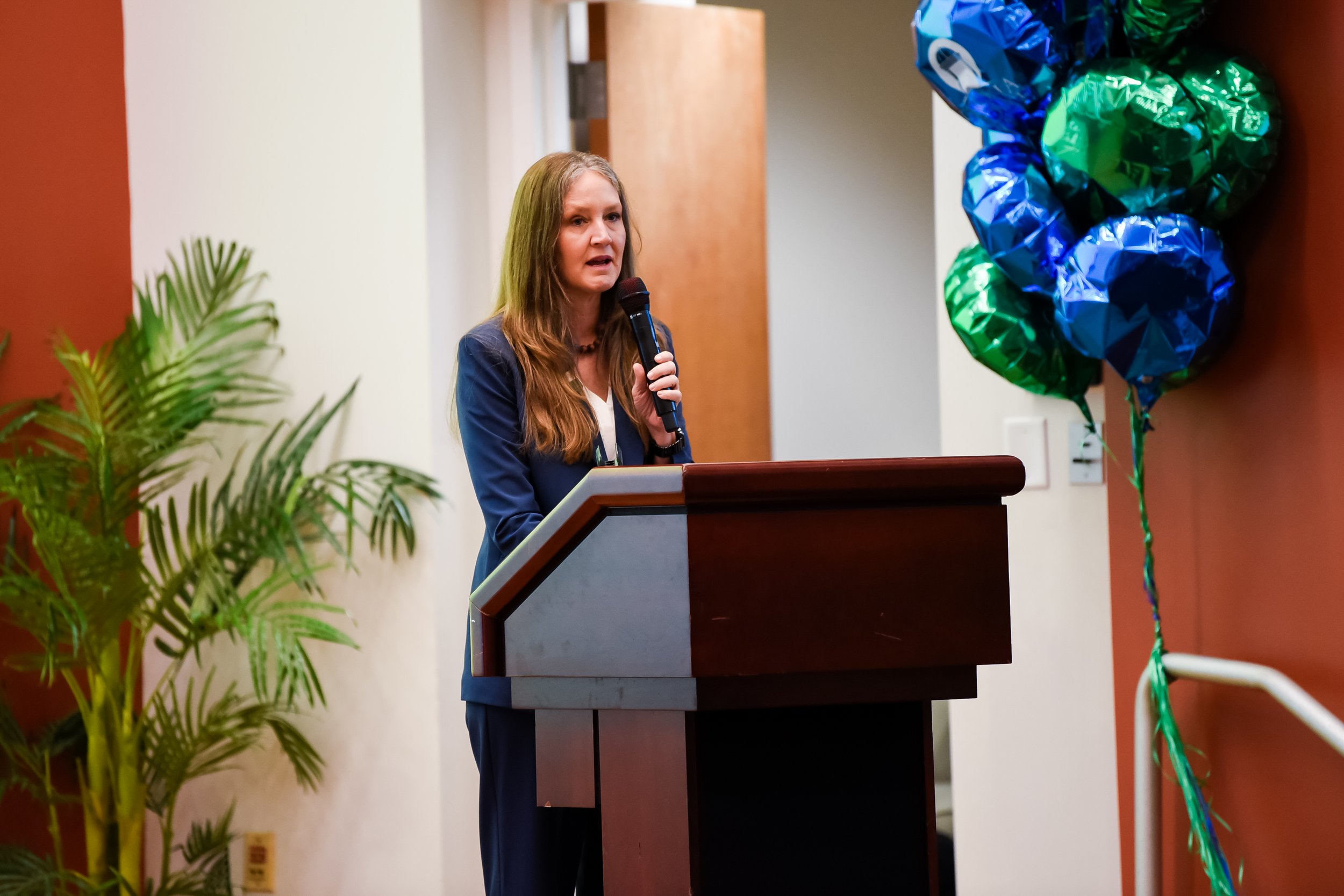 Woman speaking at a podium during a conference.