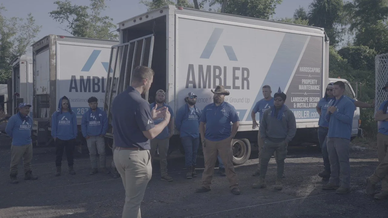 Ambler Industries team meeting in front of landscaping trucks in Furlong, PA