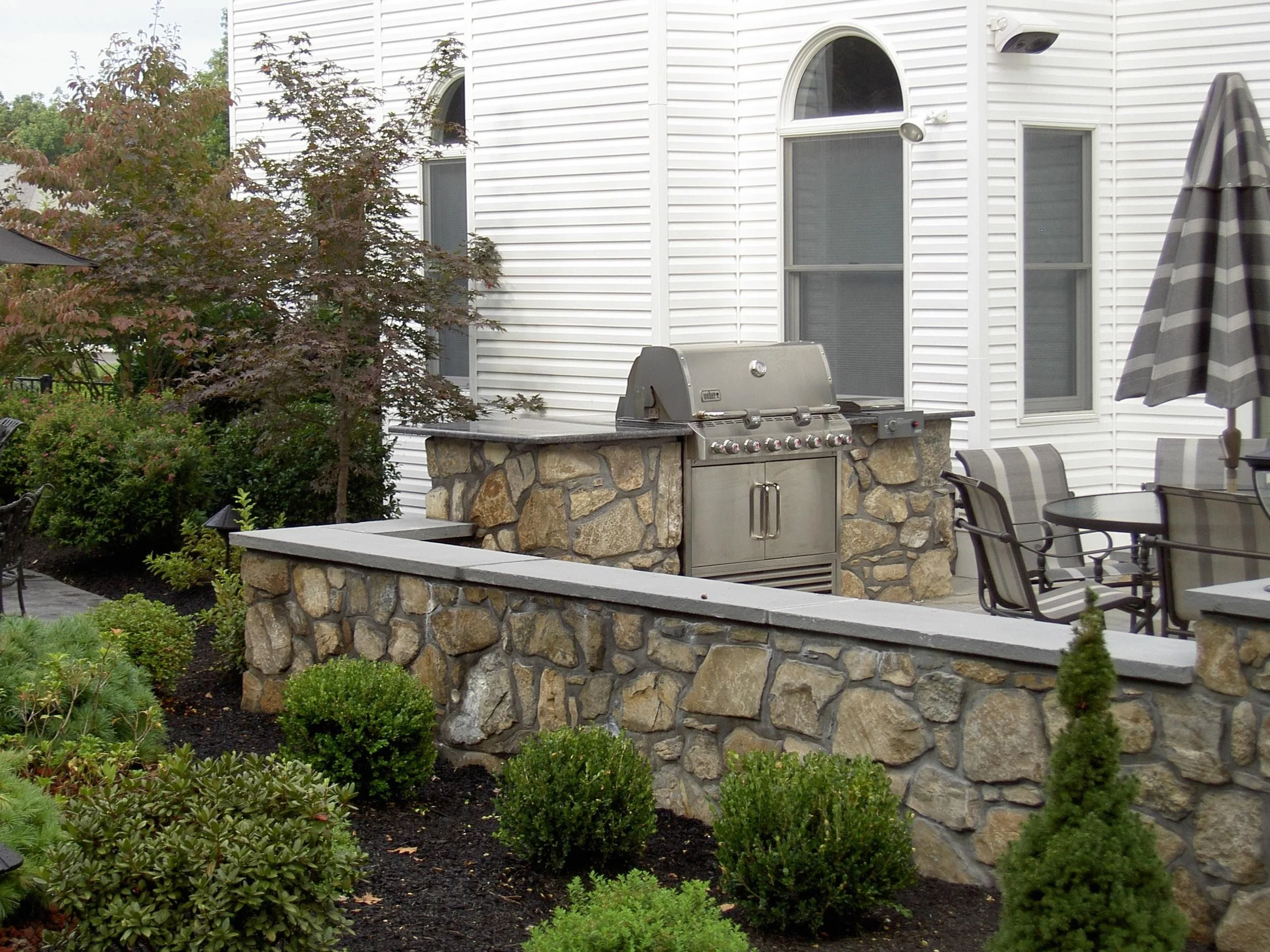 Outdoor kitchen with stone retaining wall