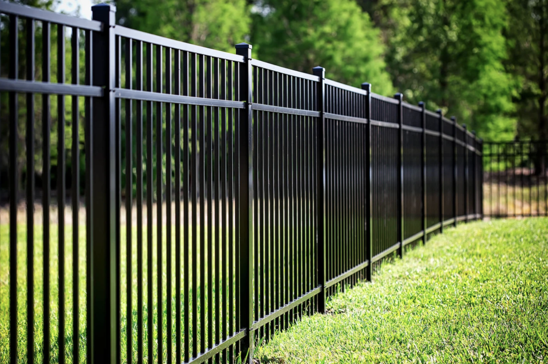 black aluminum fencing and green grass