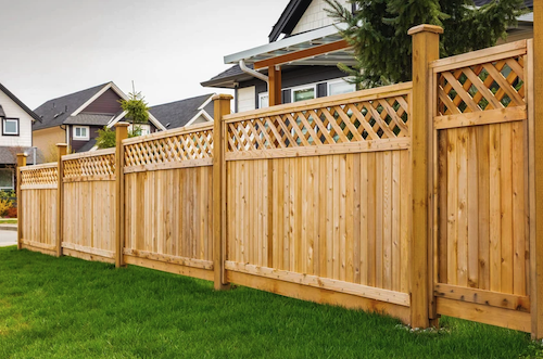 wood fencing and green grass dividing residential properties