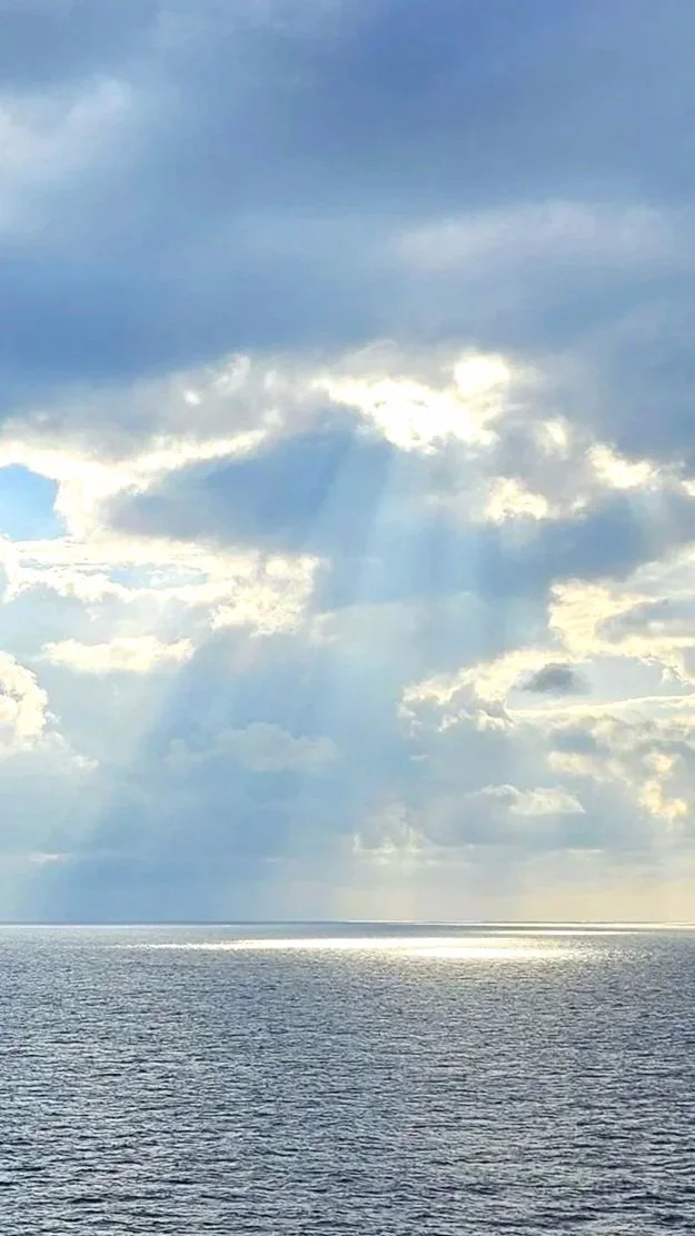 Light shining through clouds over the ocean
