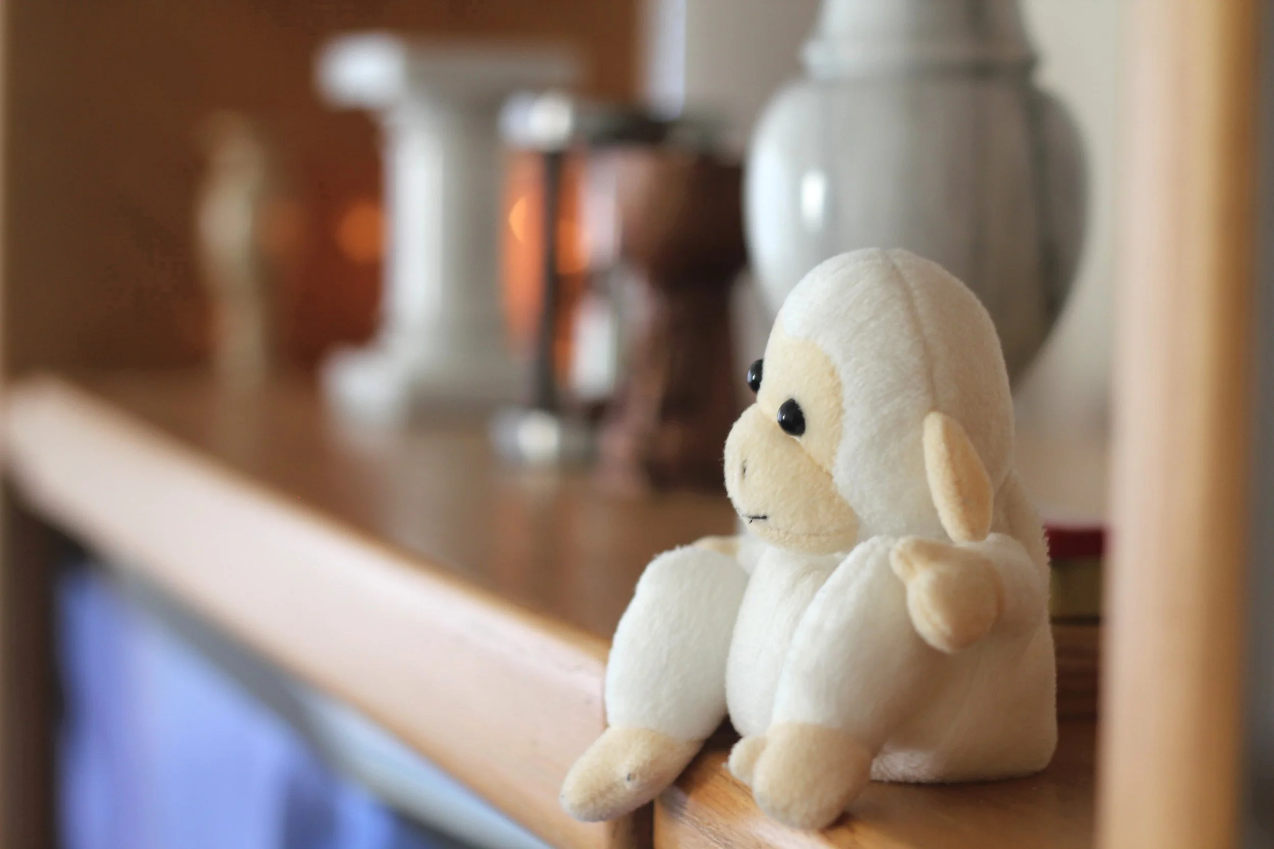 Small monkey toy sittinglonely on a shelf like a forgotten piece of childhood.
