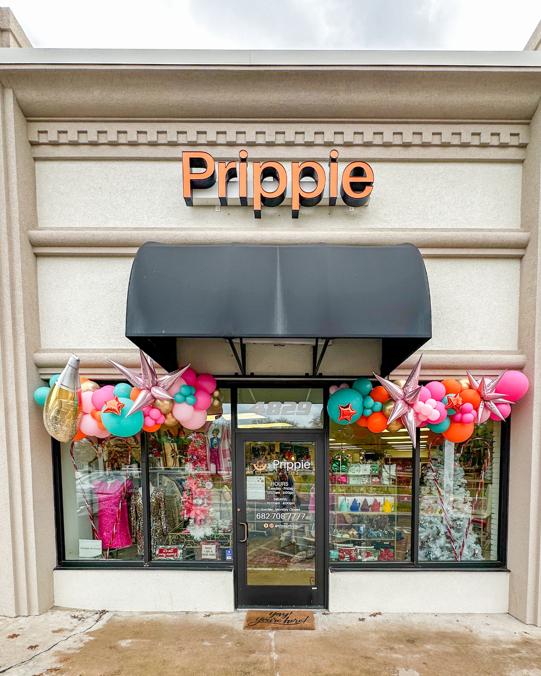 Front entrace to Prippie with orange, blue, and pink balloons above the window