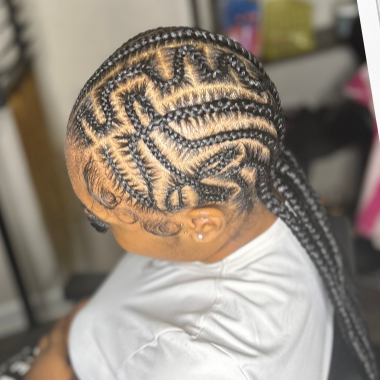 Girl with intricate cornrow hairstyle featuring geometric patterns and designs