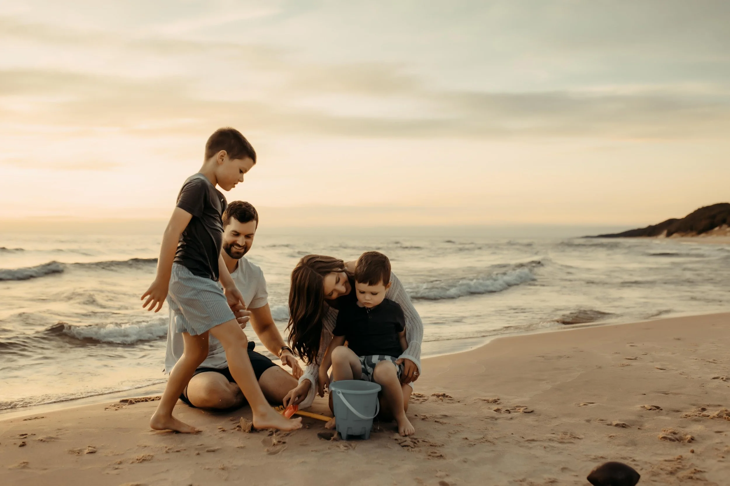 family playing and make sand castles on the beach documenting their children's childhood
