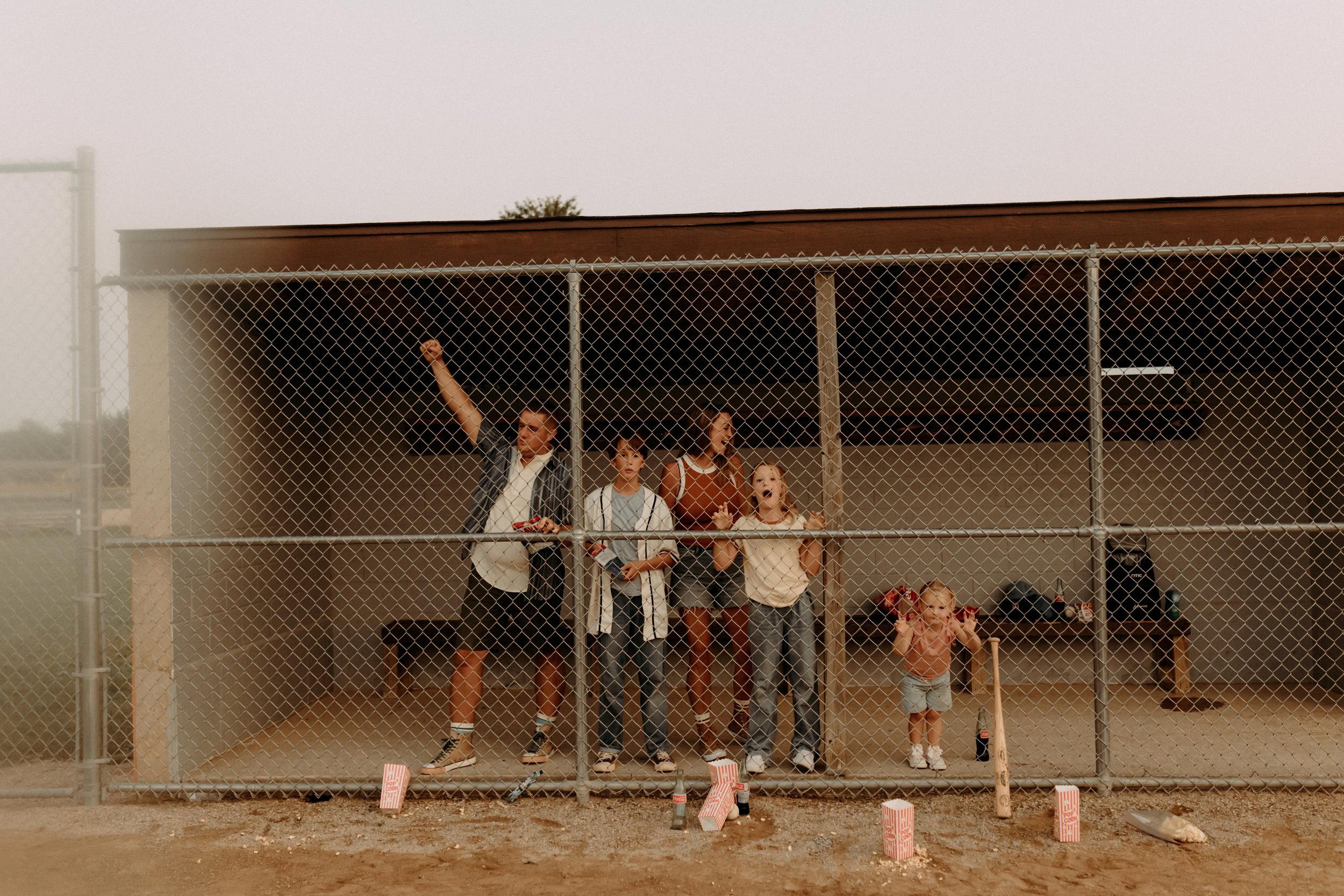 Family cheering in the dug out at a baseball diamond during a photoshoot in west michigan