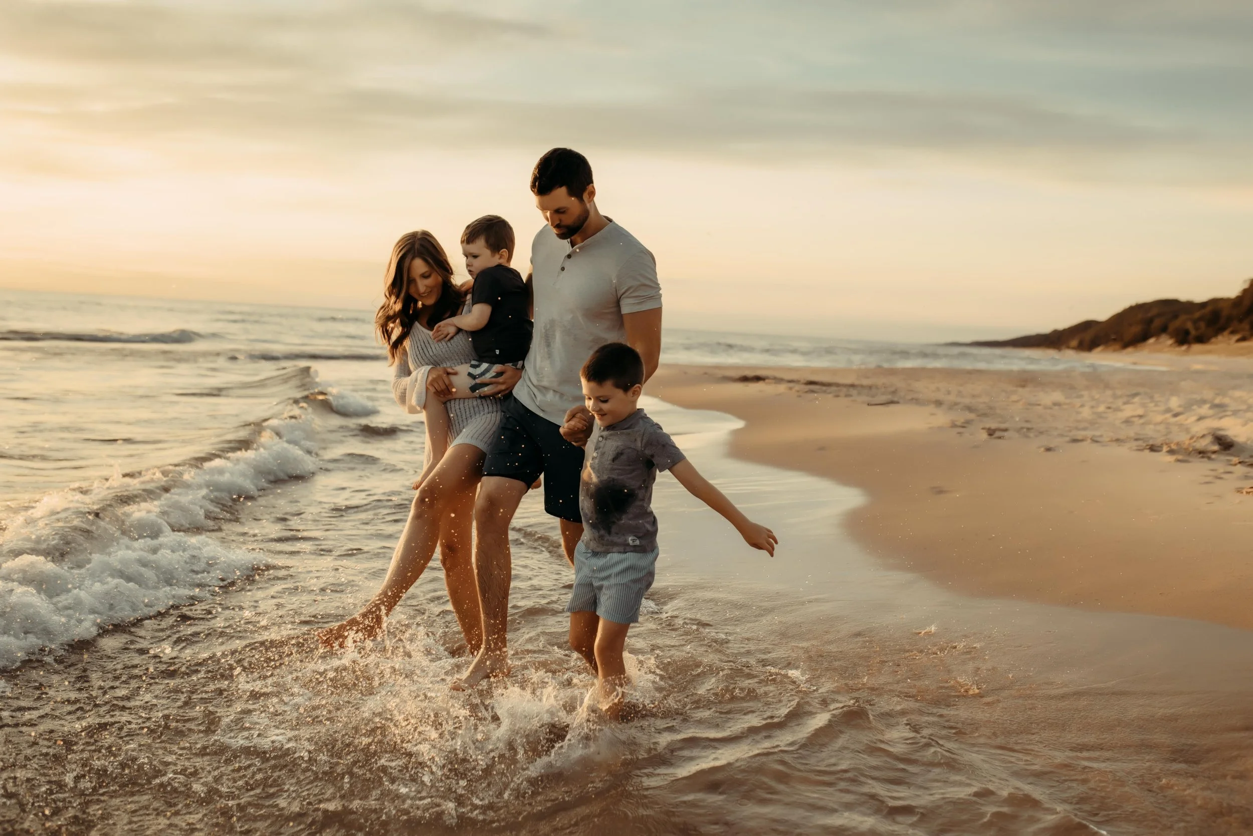 family playing together on the shores of grand haven beach in michigan