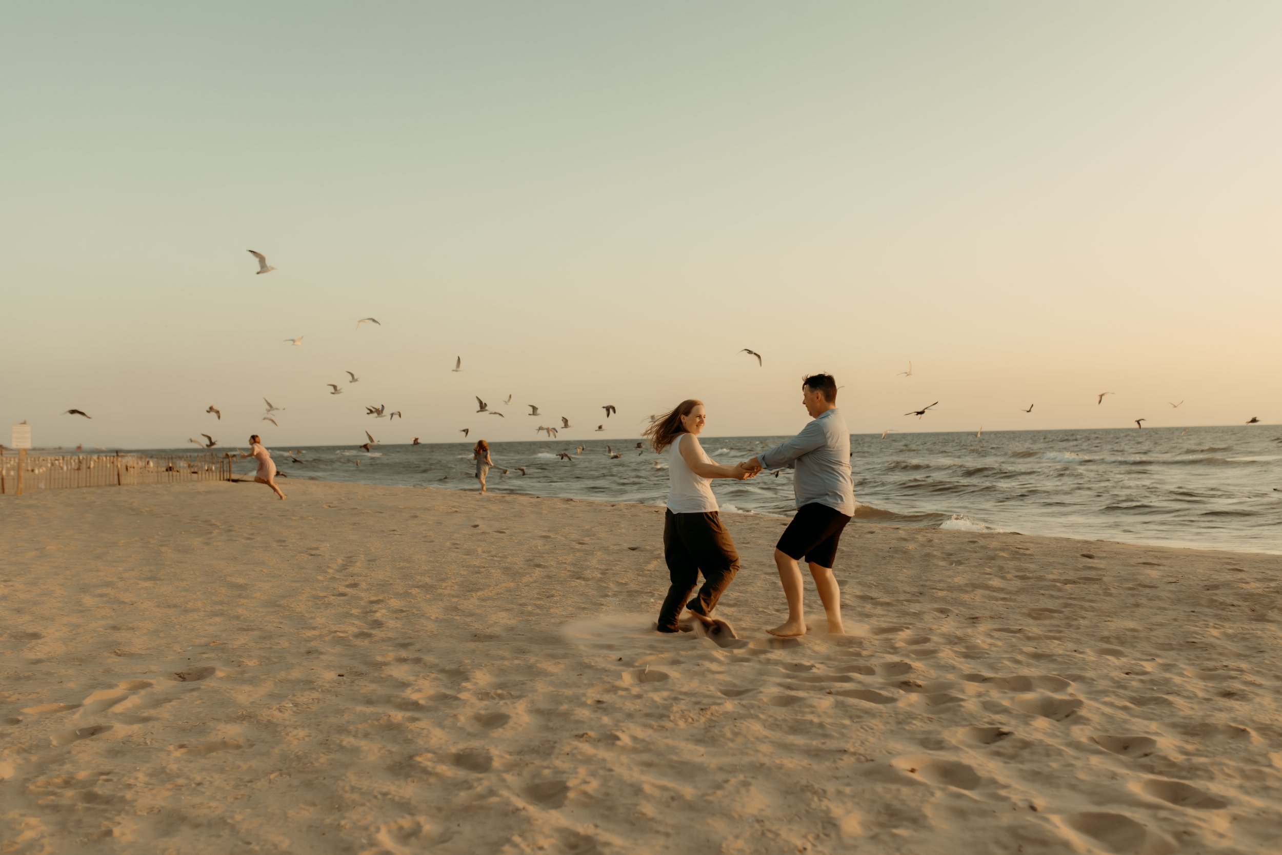 Family playing at the beach and chasing seagulls in Holland, Michigan at Tunnel Park