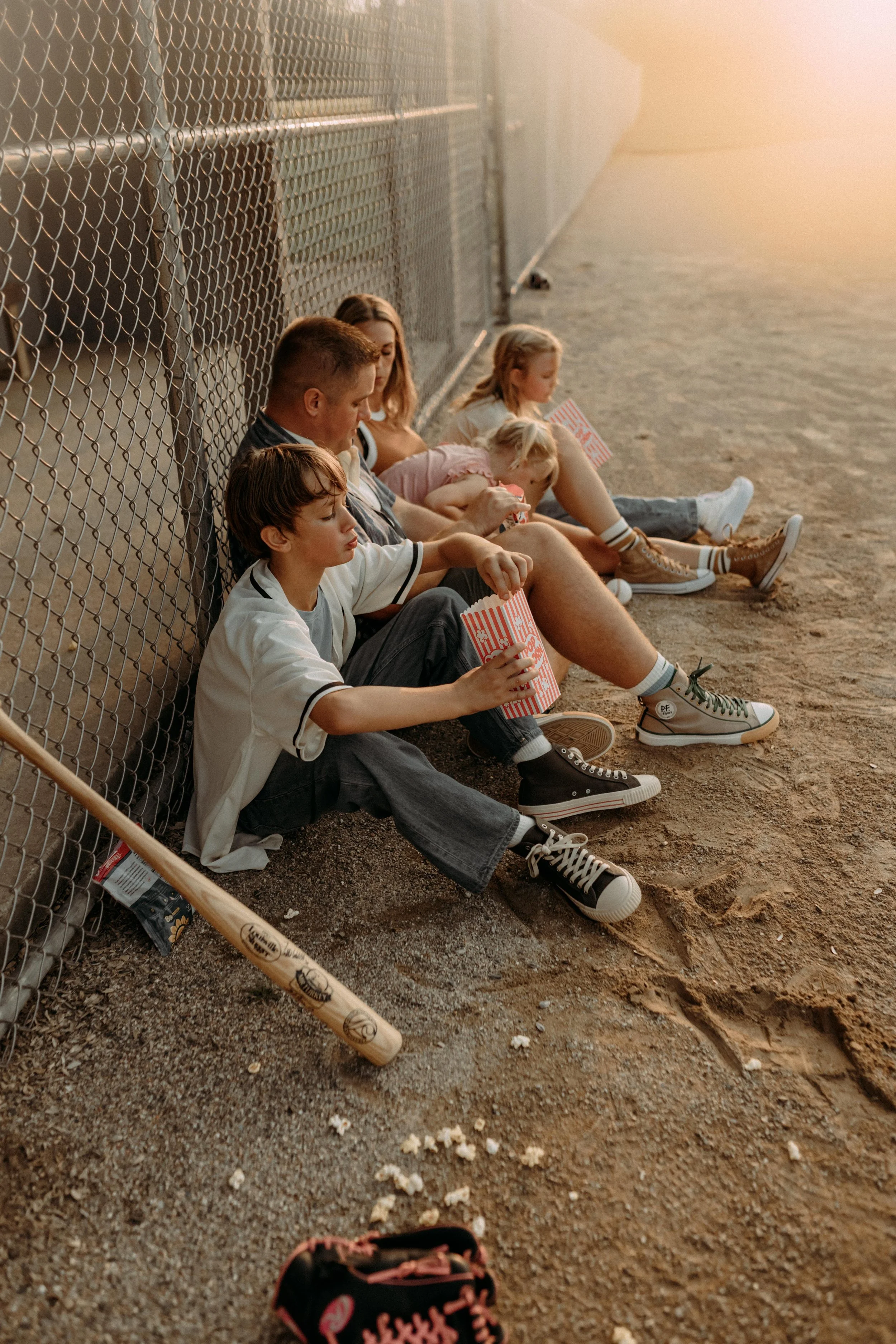 family playing at the baseball fields eating snacks photography session grand rapids, michigan