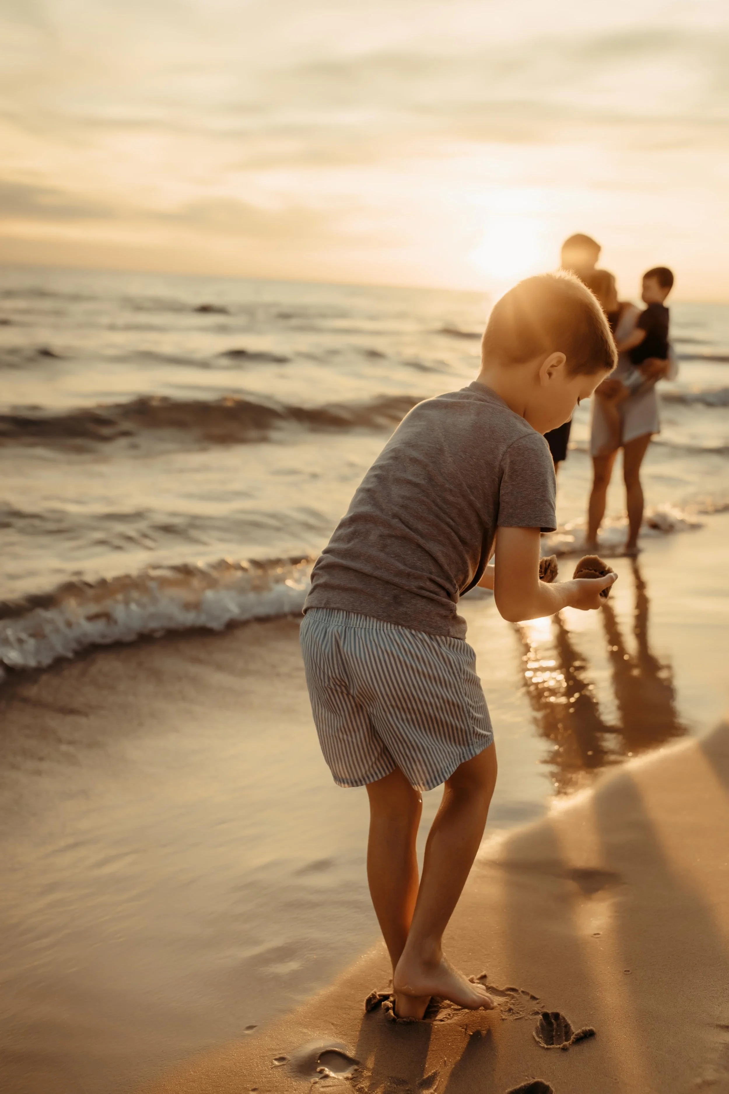 child playing with sand at lake michigan in grand haven beach