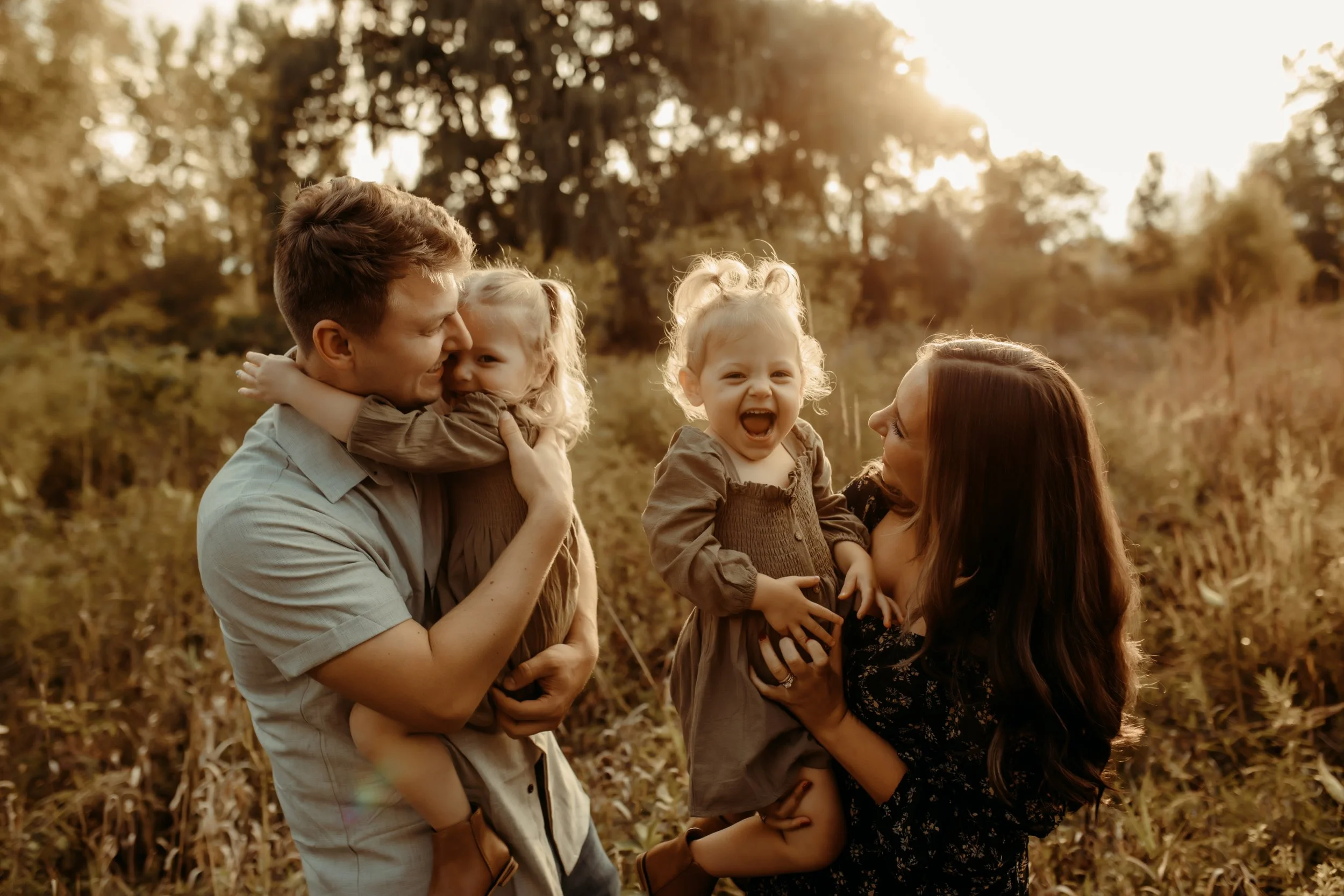Family playing and laughing in a field in Grand Rapids, Michigan during family photography session