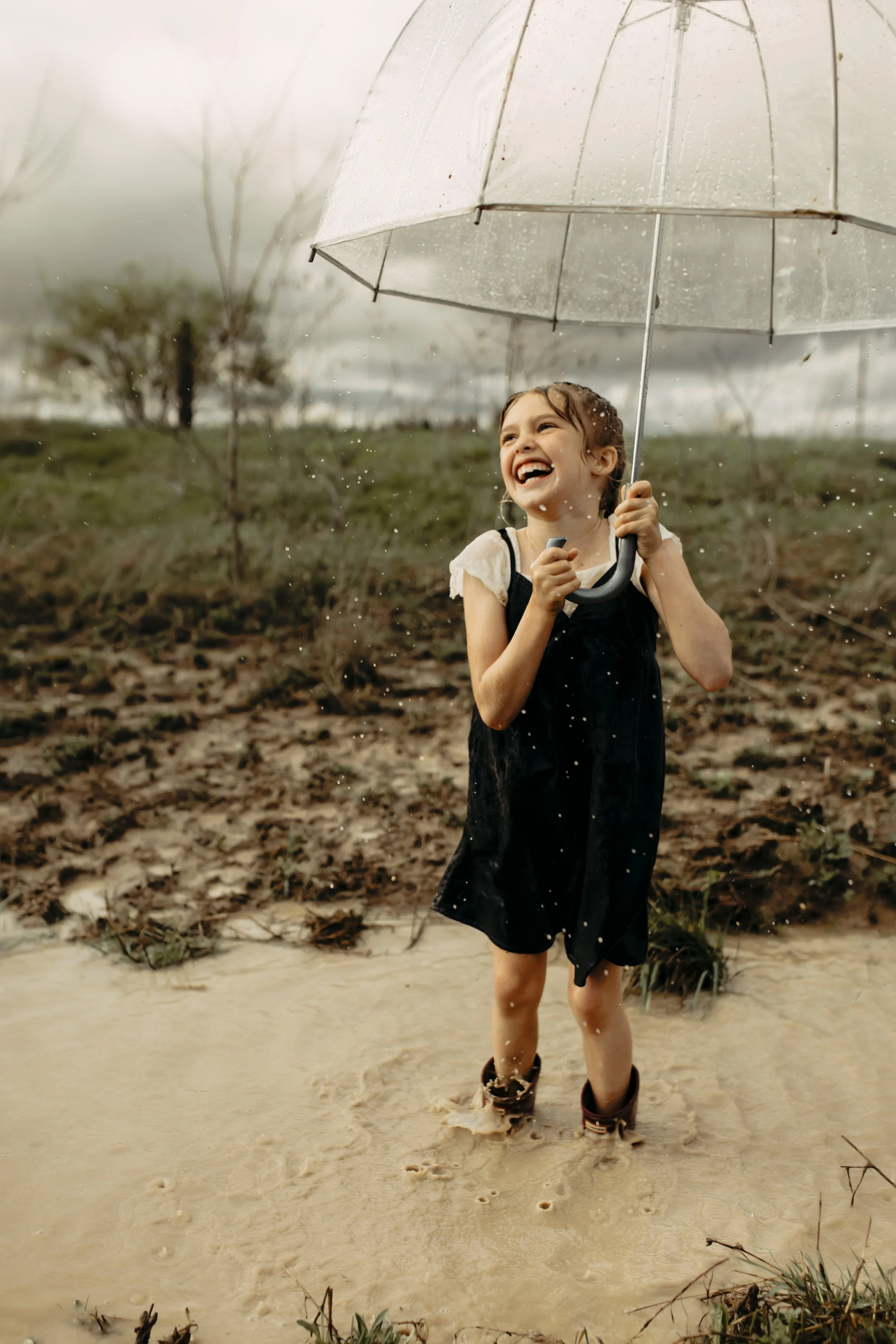 Family photography session in Hudsonville, Michigan with girl playing in the rain