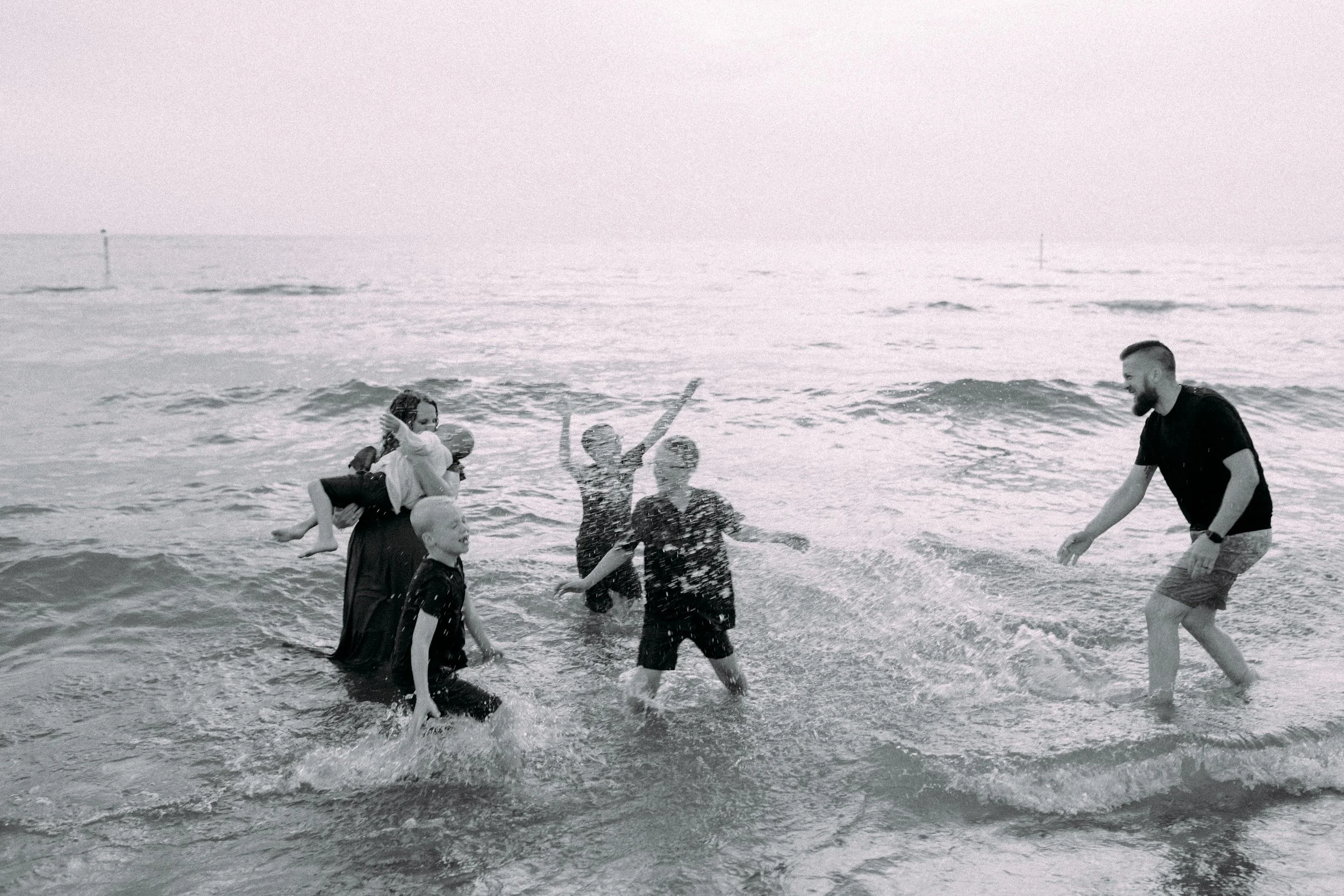 Family splashing and playing at photography session in Holland, Michigan at Tunnel Park