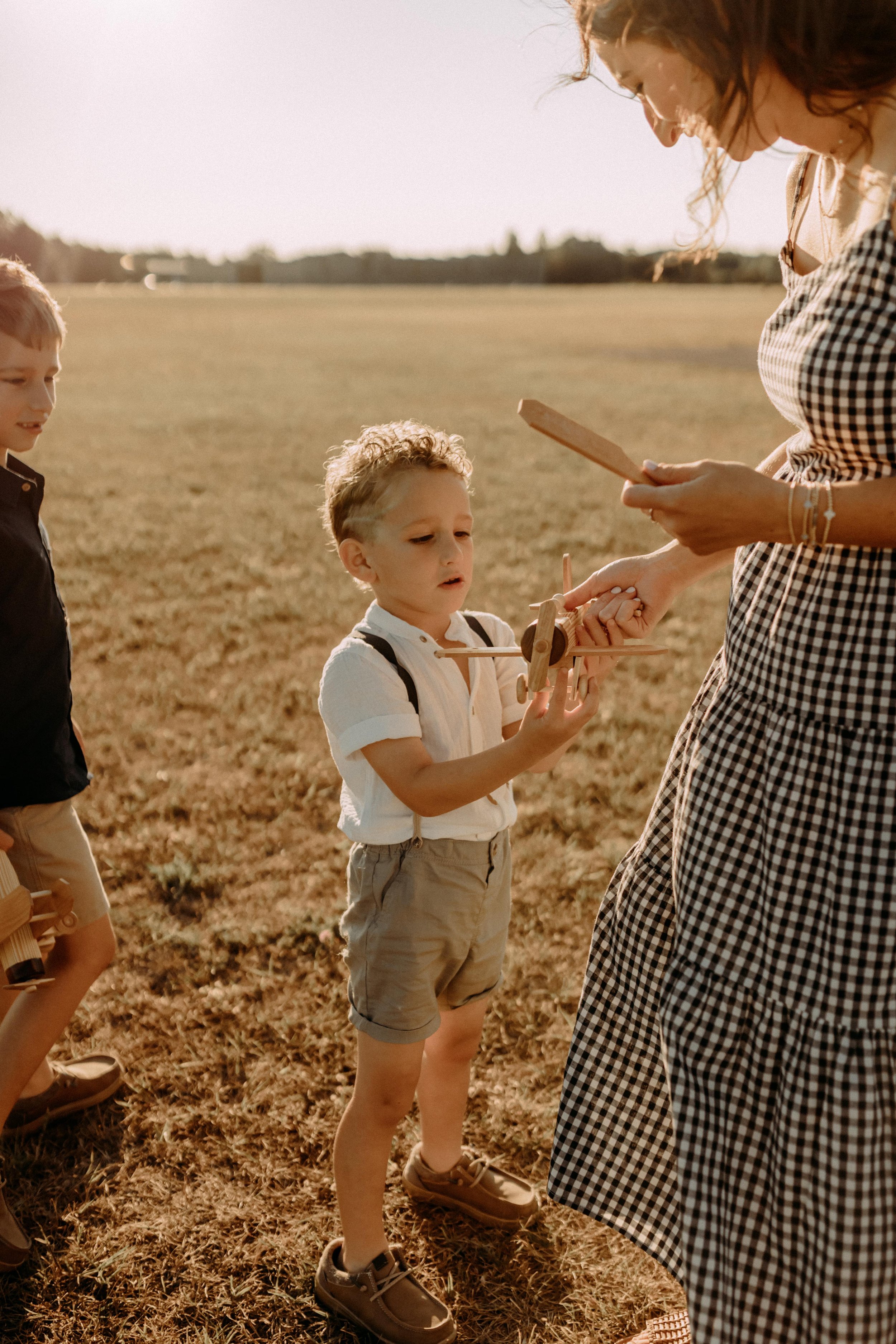 wooden airplane broken during family photography session showing the realness of life