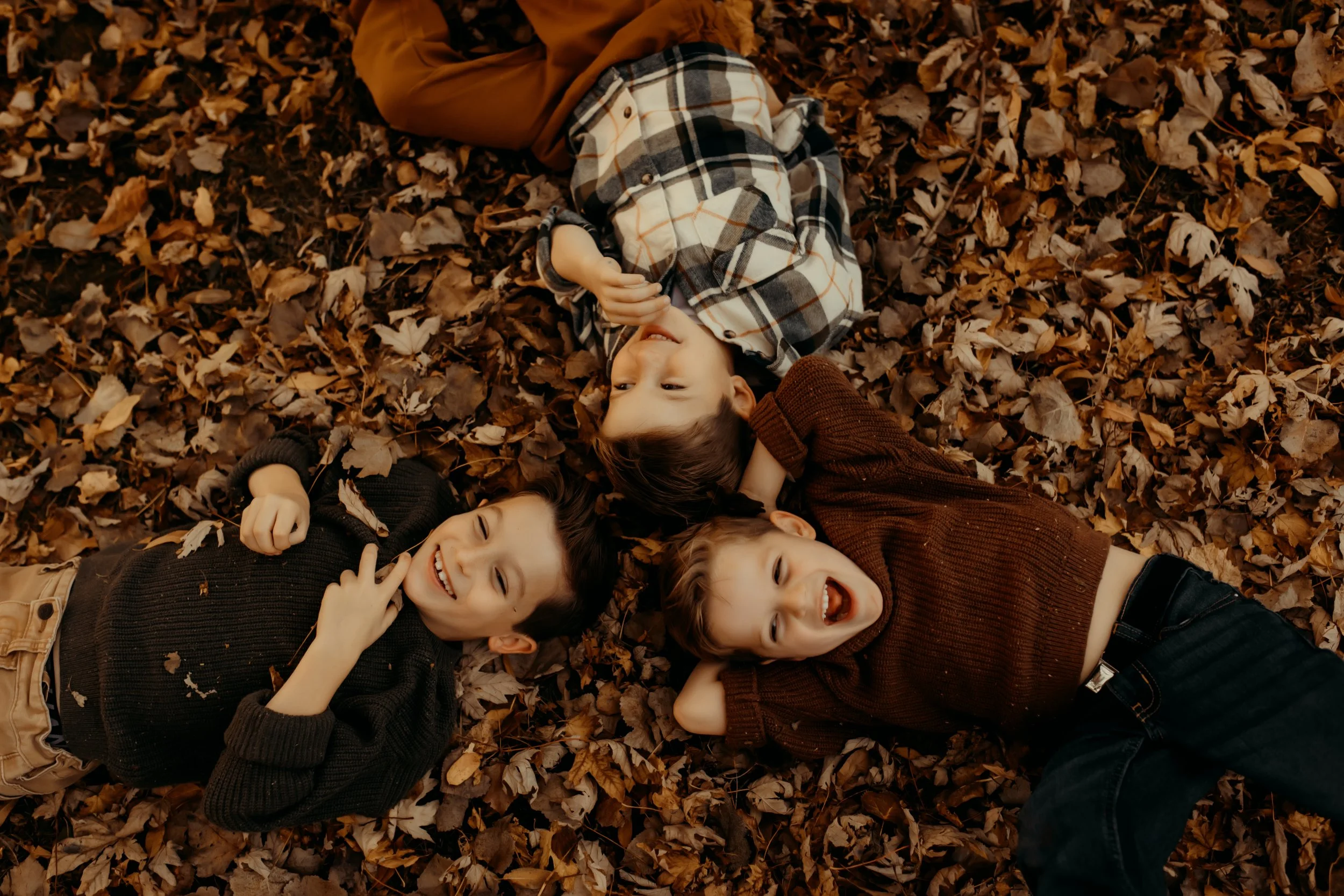 boys playing in the leaves during a fall documentary photography session