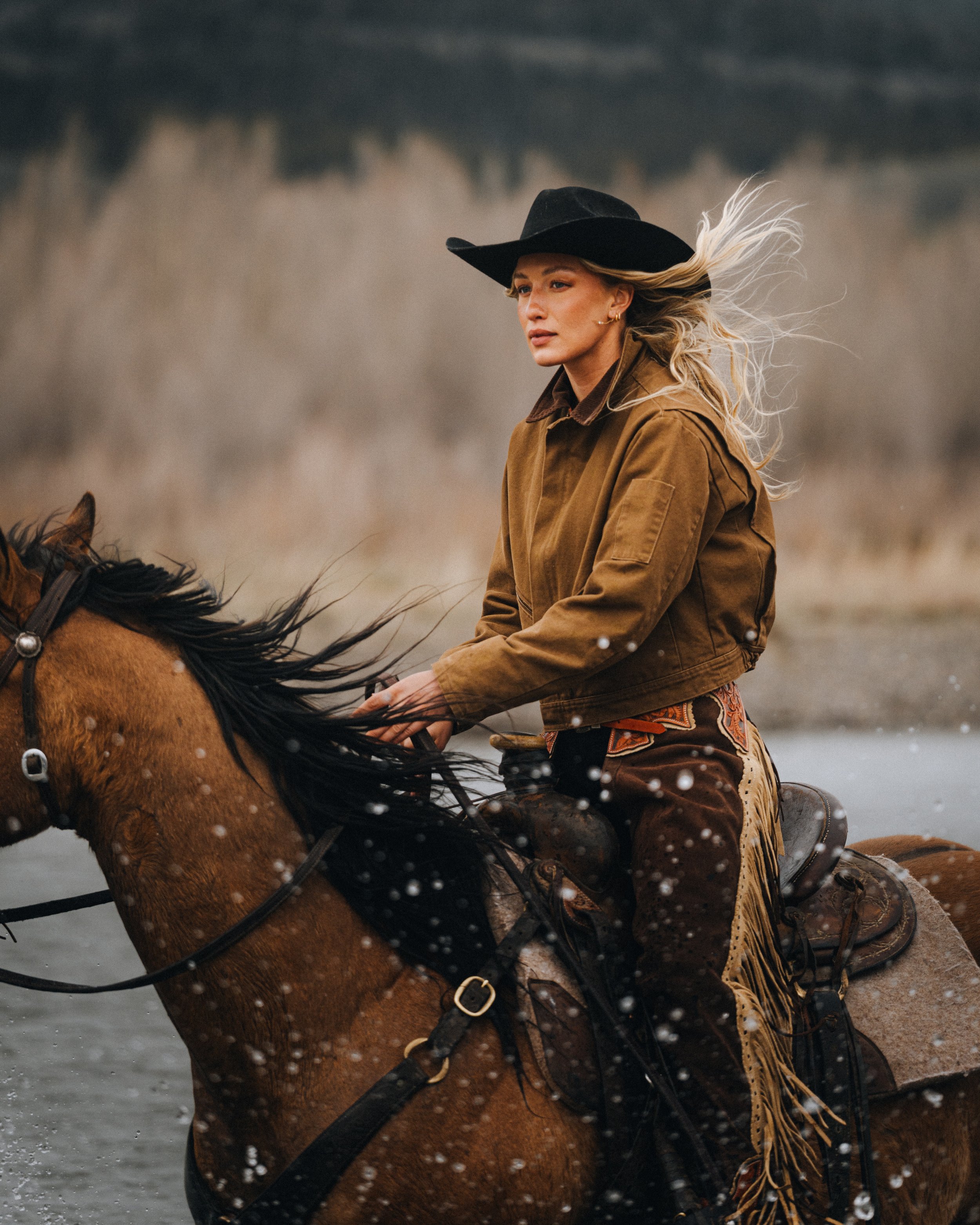 cowgirl riding horse in river