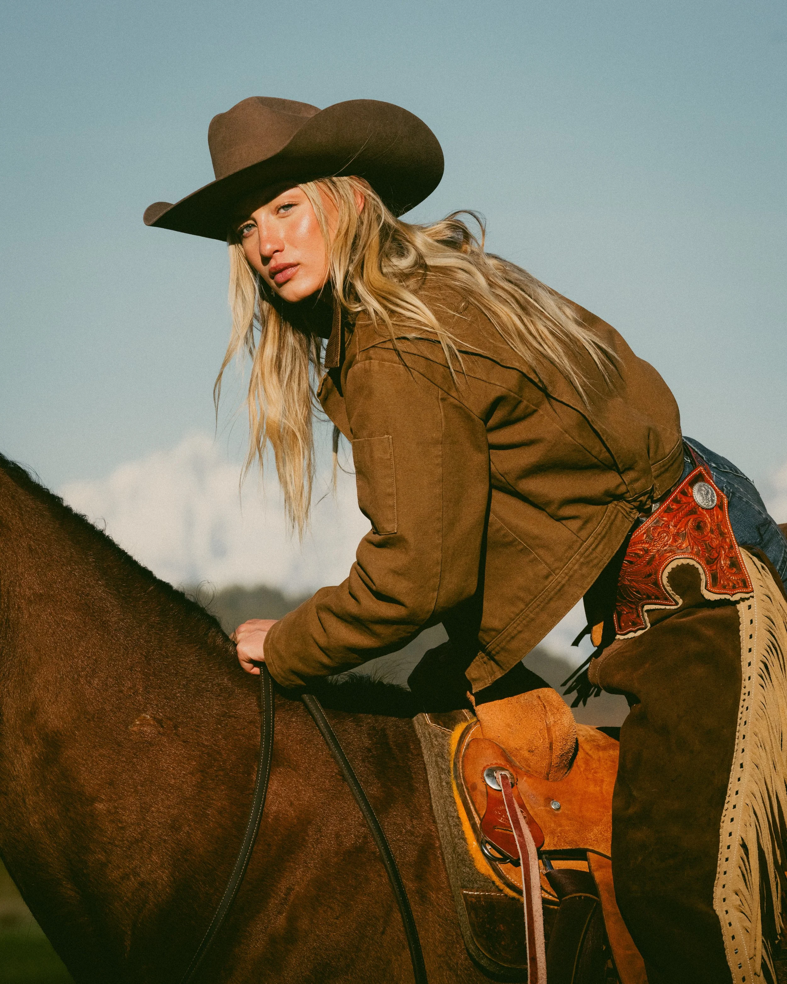 cowgirl mounting horse at sunrise 