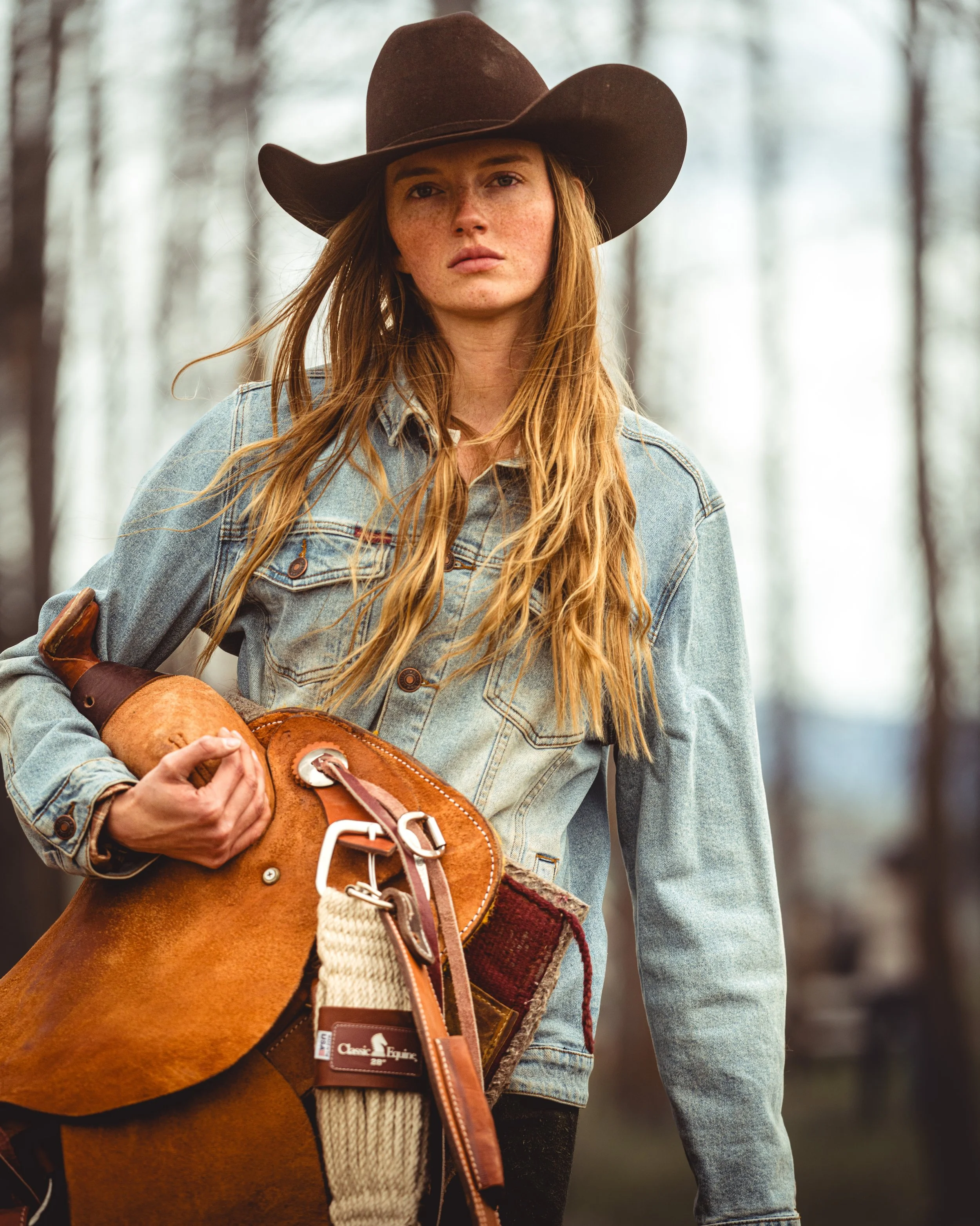 cowgirl holding saddle