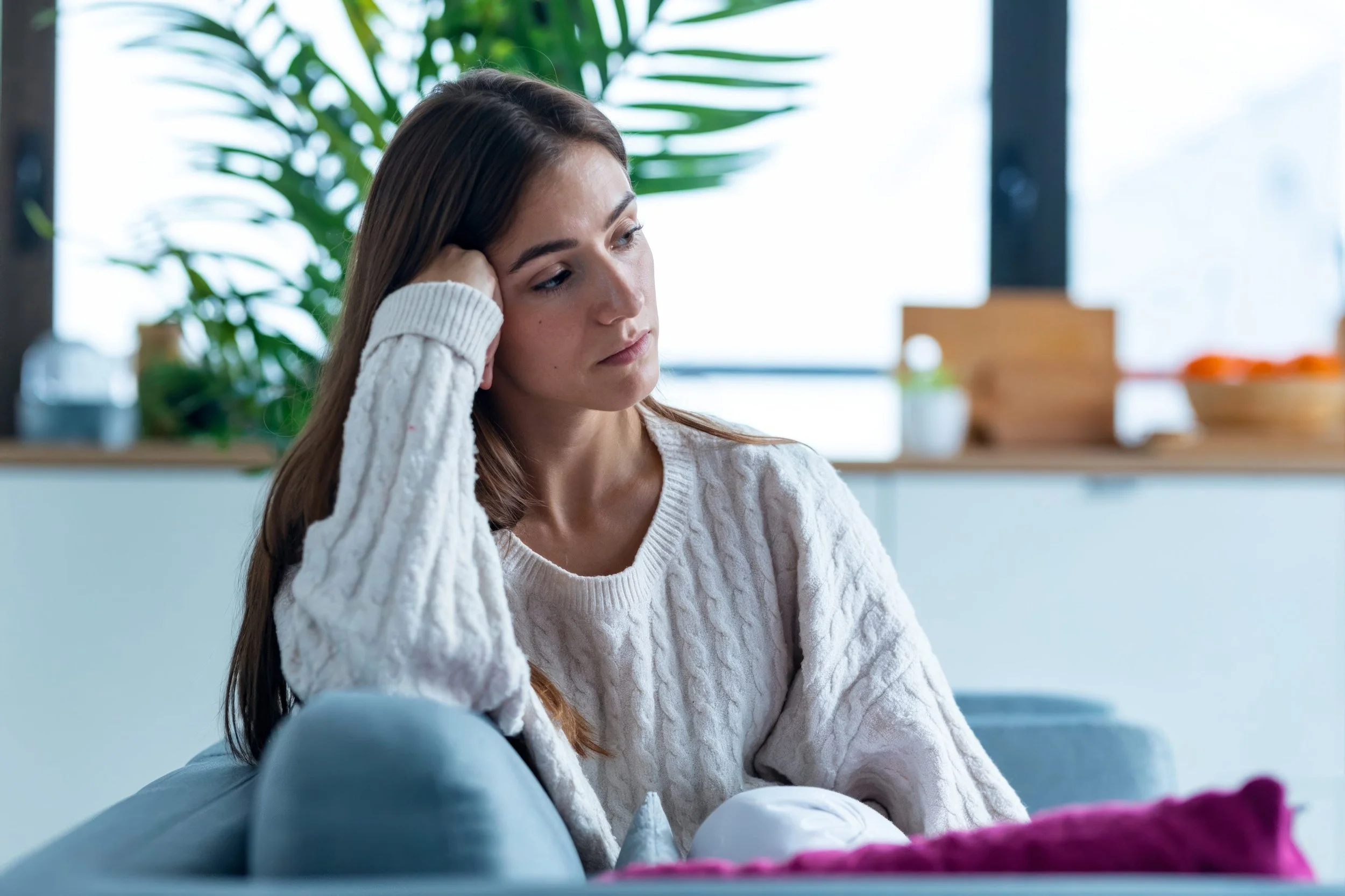 woman sitting alone looking thoughtful and uncertain wondering if OCD will get better