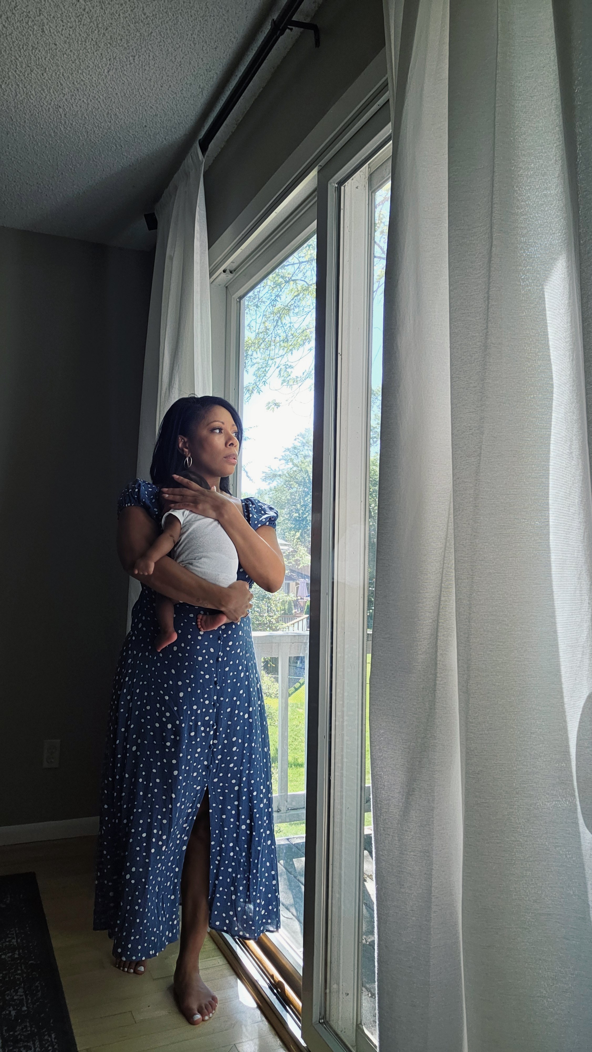 mother and baby walk by window