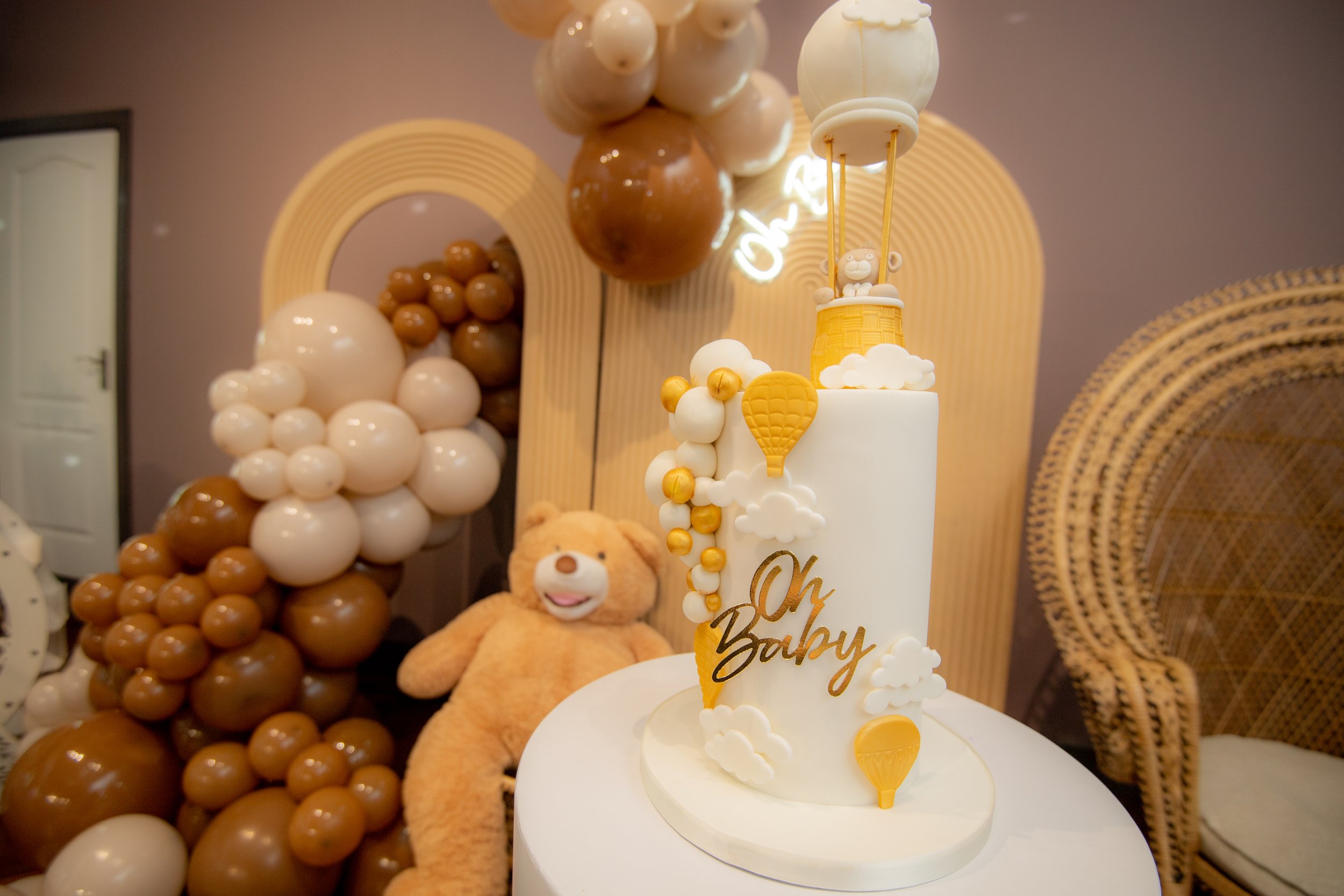 Elegant baby shower cake with hot air balloon topper and “Oh Baby” decoration at luxury baby shower venue