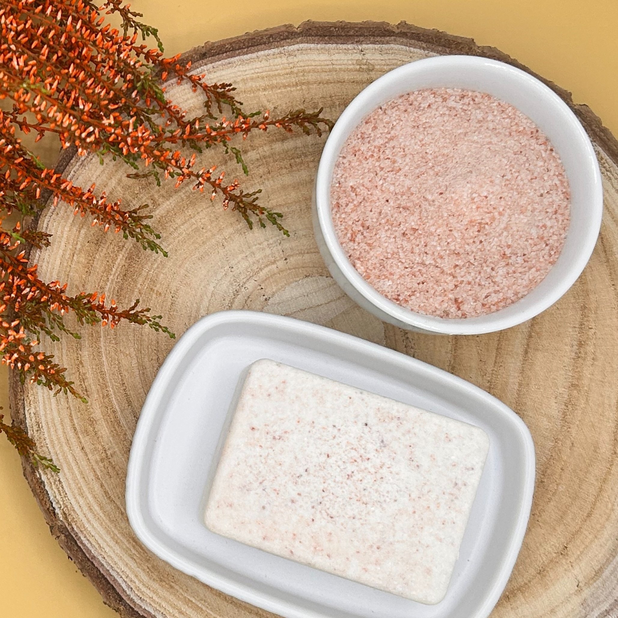 Patchouli, Geranium and French Red Clay - Himalayan Pink Salt Soap on a slice of wood and a bowl of salt.