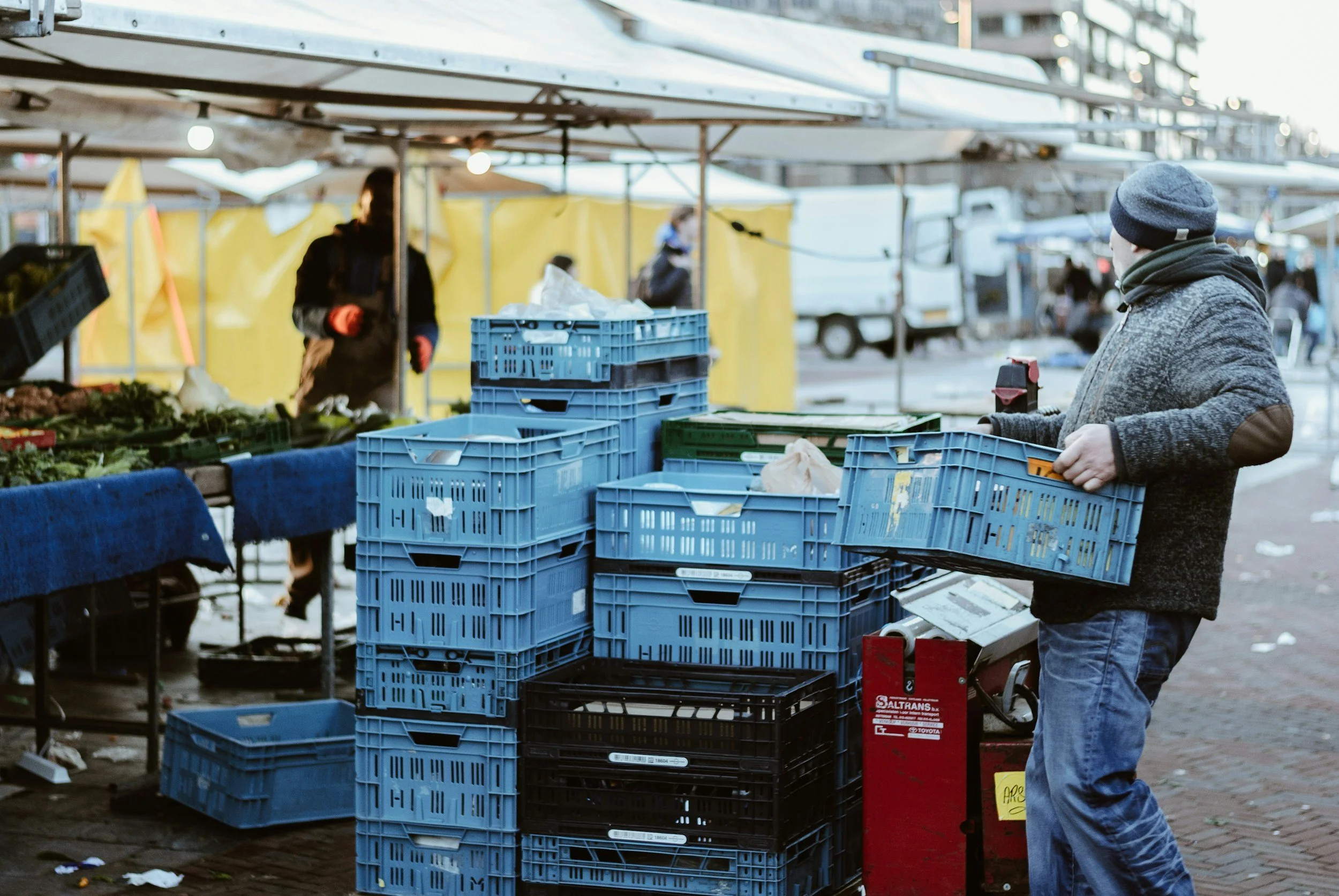 Street market with vendor and plastic crates