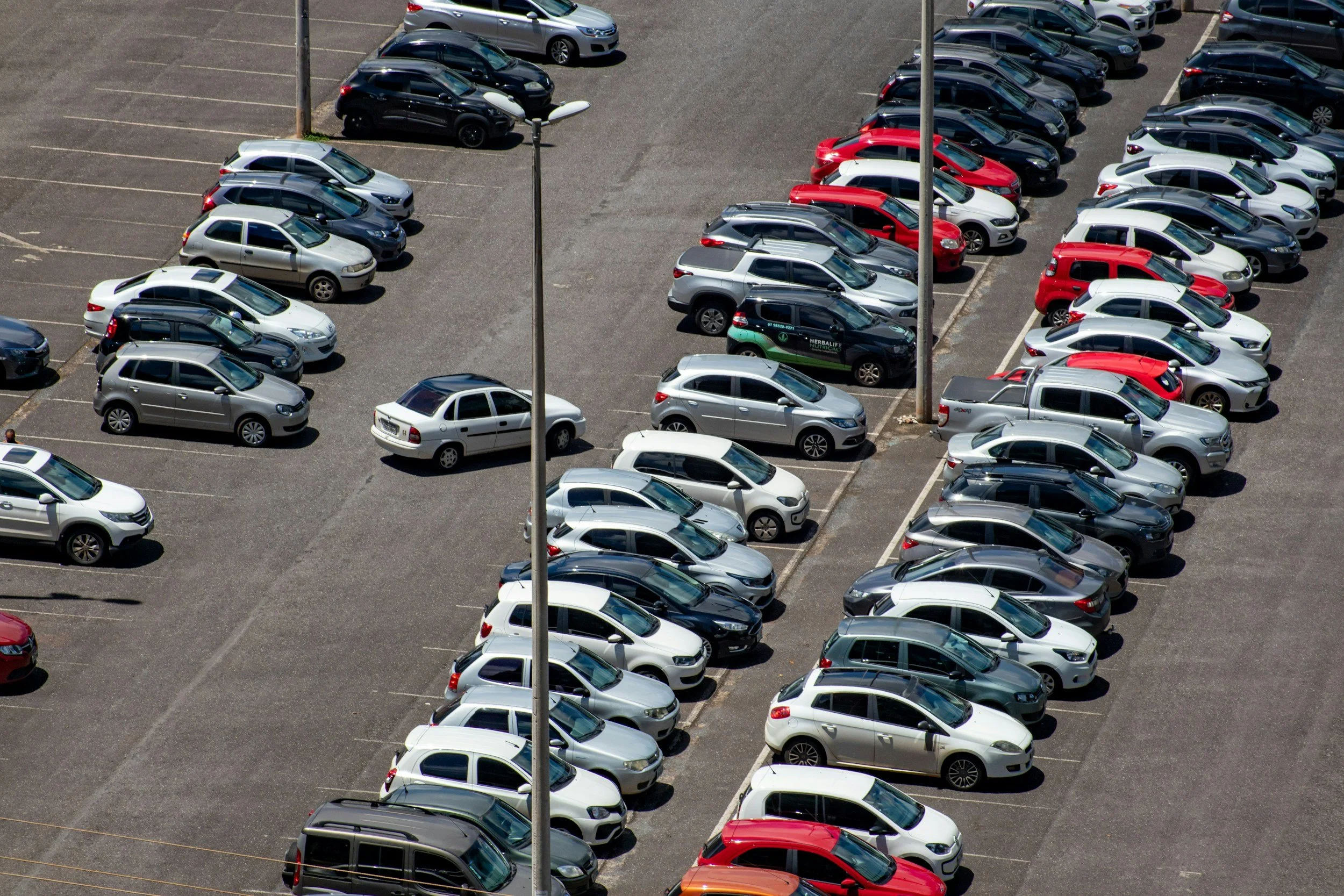 rows of cars parked adjacent to each other in an open air car park