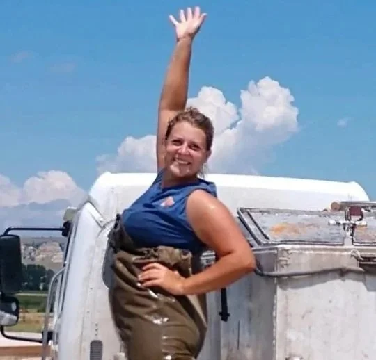 Melissa Murray, owner of FML Aquaculture, waving from a fish transport truck during a pond stocking delivery.