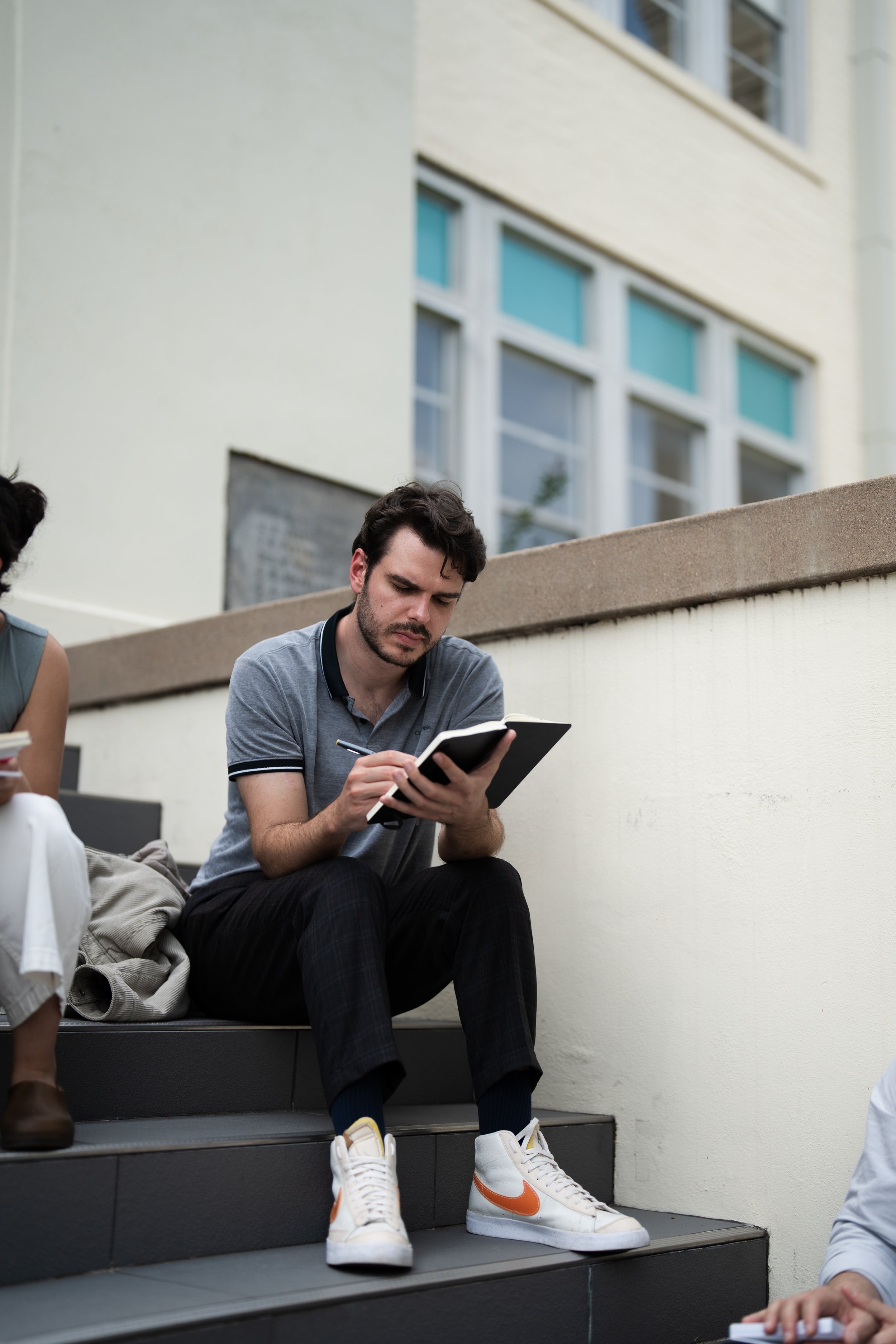 Design Fellow Ryan writing notes outside
