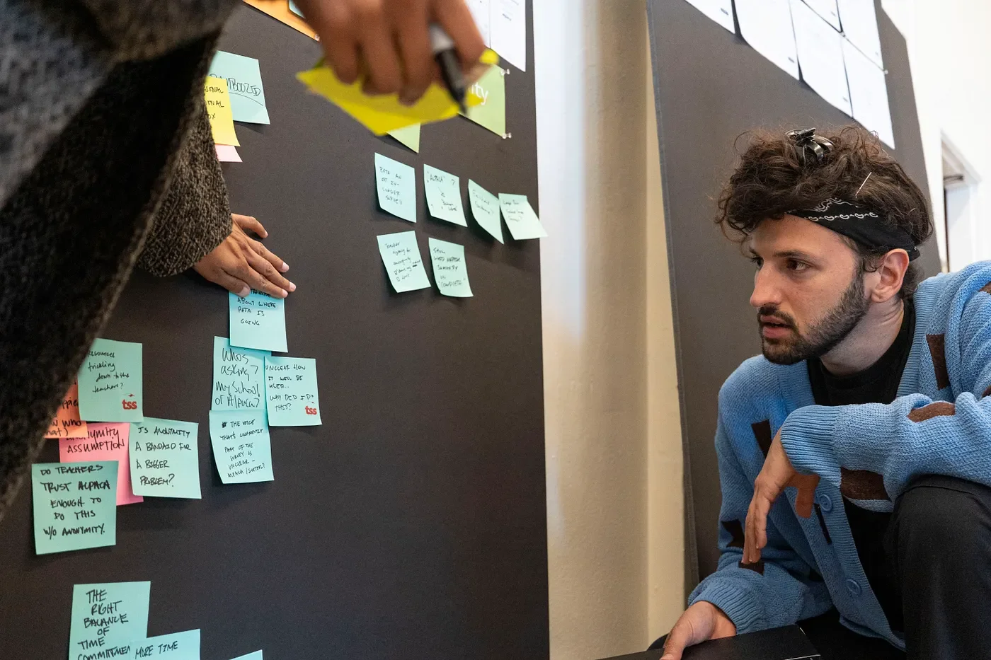 David reading post-its on pin up board