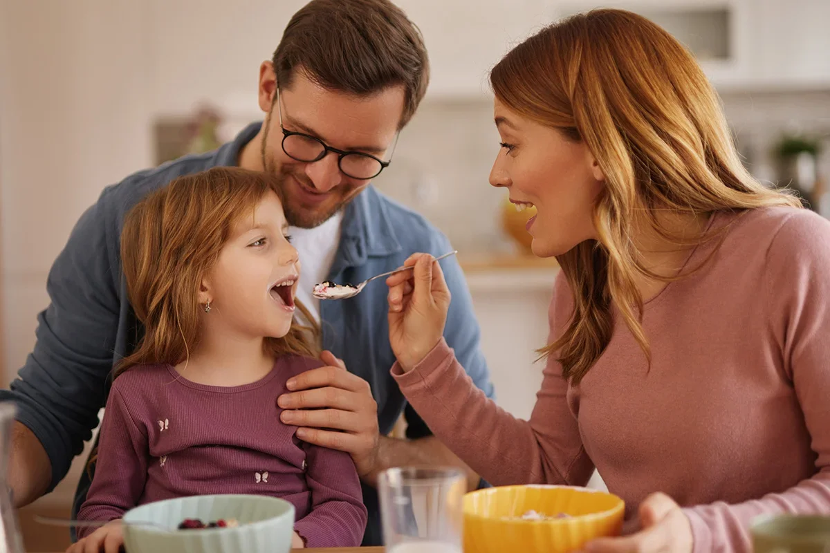 Young family eating breakfast together, illustrating how Consumer segmentation research UK uncovers needs-based differences among family households to help brands tailor products, messaging, and innovation strategies effectively.