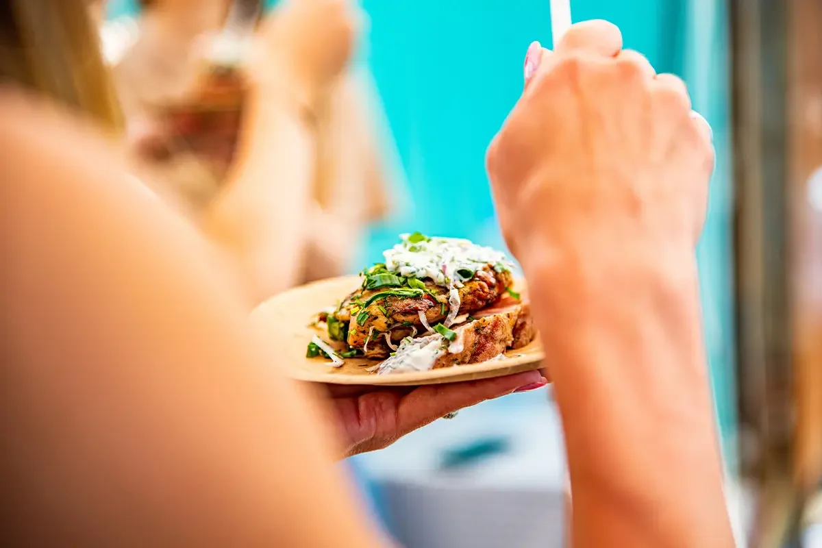 Close-up of a person holding a plate of food during product testing and benchmarking, showcasing fresh ingredients and consumer engagement as part of product testing and benchmarking for taste, presentation, and quality.
