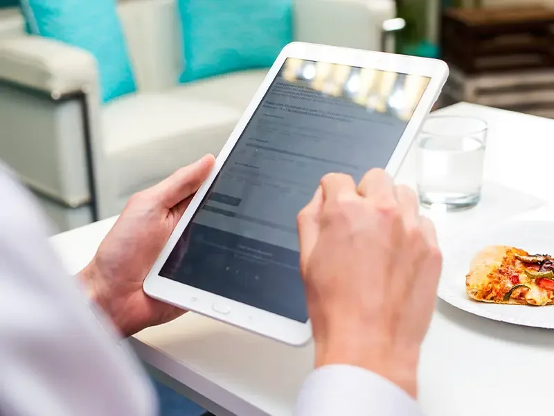 Research participant completing a digital survey on a tablet with food sample nearby, demonstrating how shopper behaviour research collects insights on preferences and decision-making through shopper behaviour research studies.