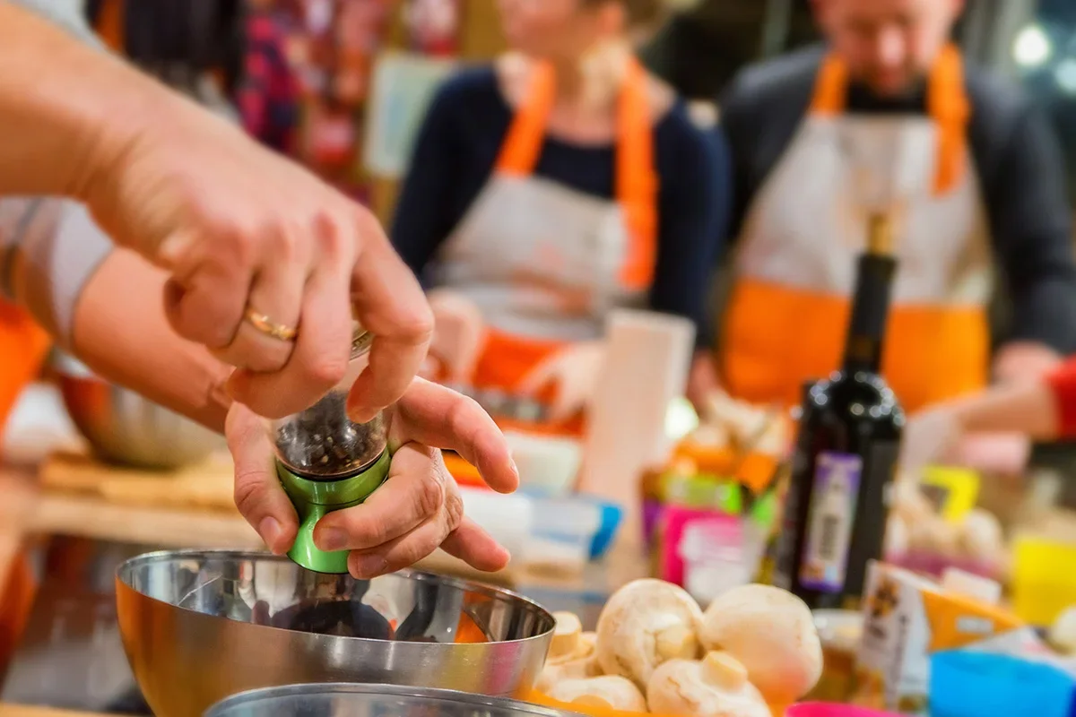 Hands preparing food during a collaborative cooking workshop, symbolising how Consumer Closeness Research UK embeds consumer closeness within organisations by engaging teams directly with real-life consumer experiences and behaviours.