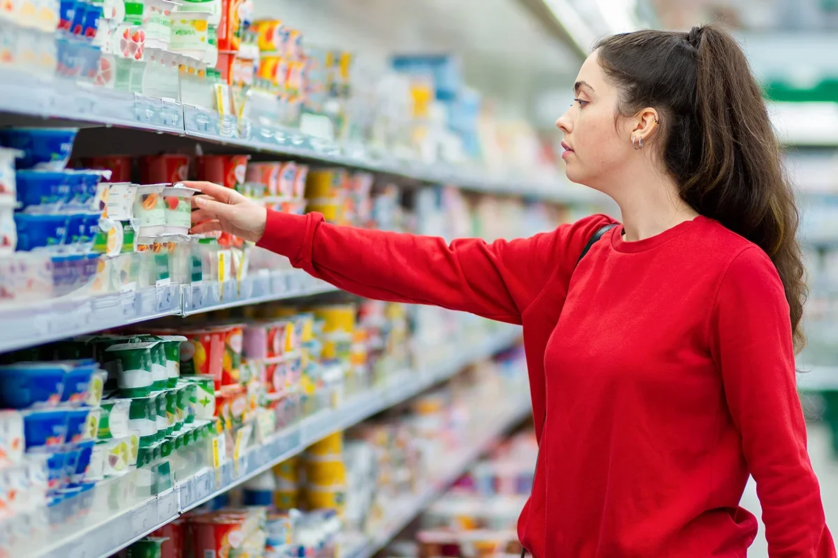 Shopper choosing products in a supermarket aisle, showing how Consumer segmentation research UK helps brands understand purchasing behaviours and activate segmentation strategies to better meet consumer needs at the point of sale.