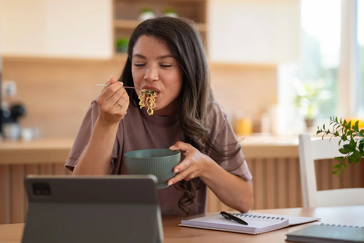 Participant eating noodles while engaging in an online study, representing how Consumer Closeness Research UK captures authentic in-the-moment food behaviours and consumer experiences to help brands understand real-life eating occasions.