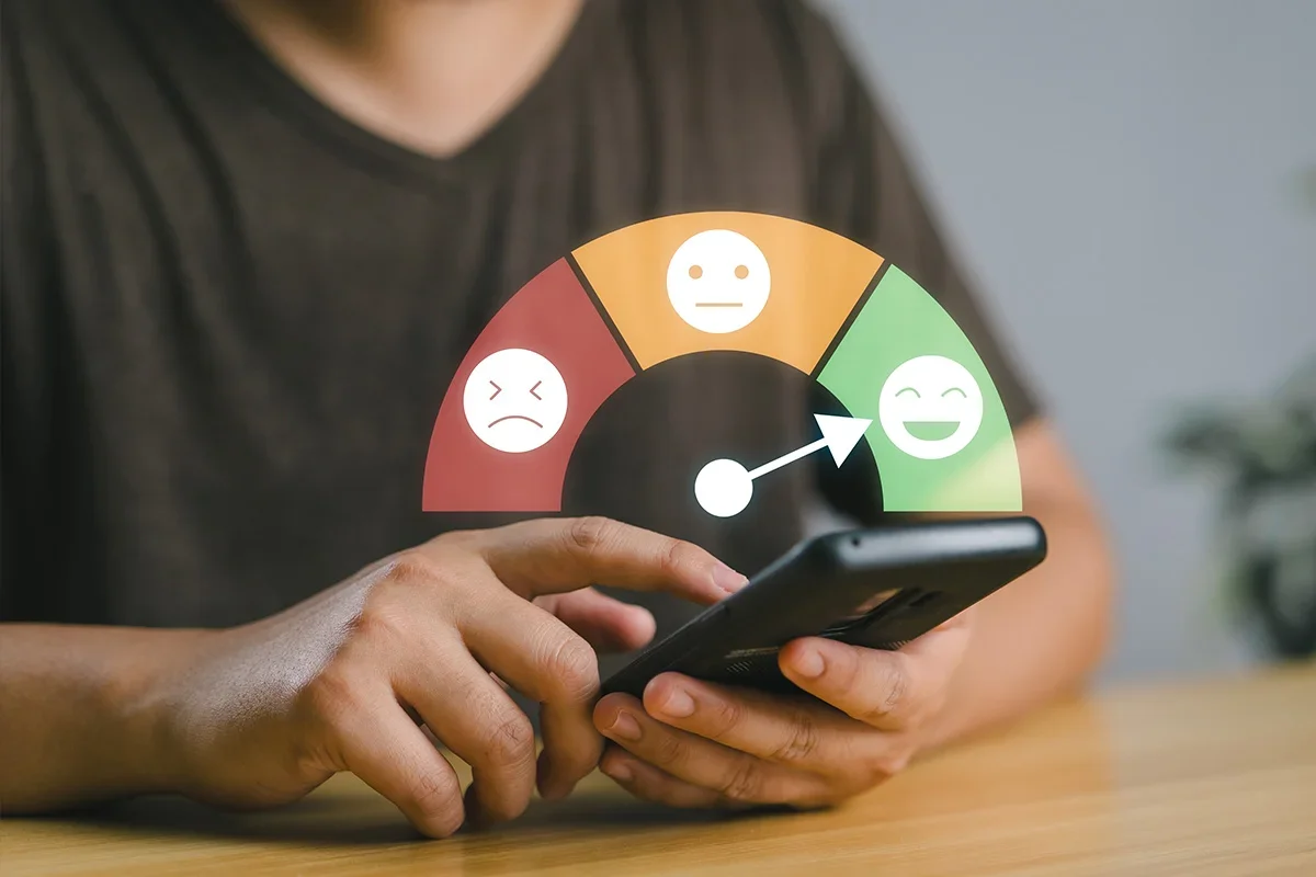 Person using a smartphone to give feedback with a satisfaction scale, illustrating how Consumer Closeness Research UK uses continuous feedback loops to track consumer sentiment and strengthen brand understanding in real time.