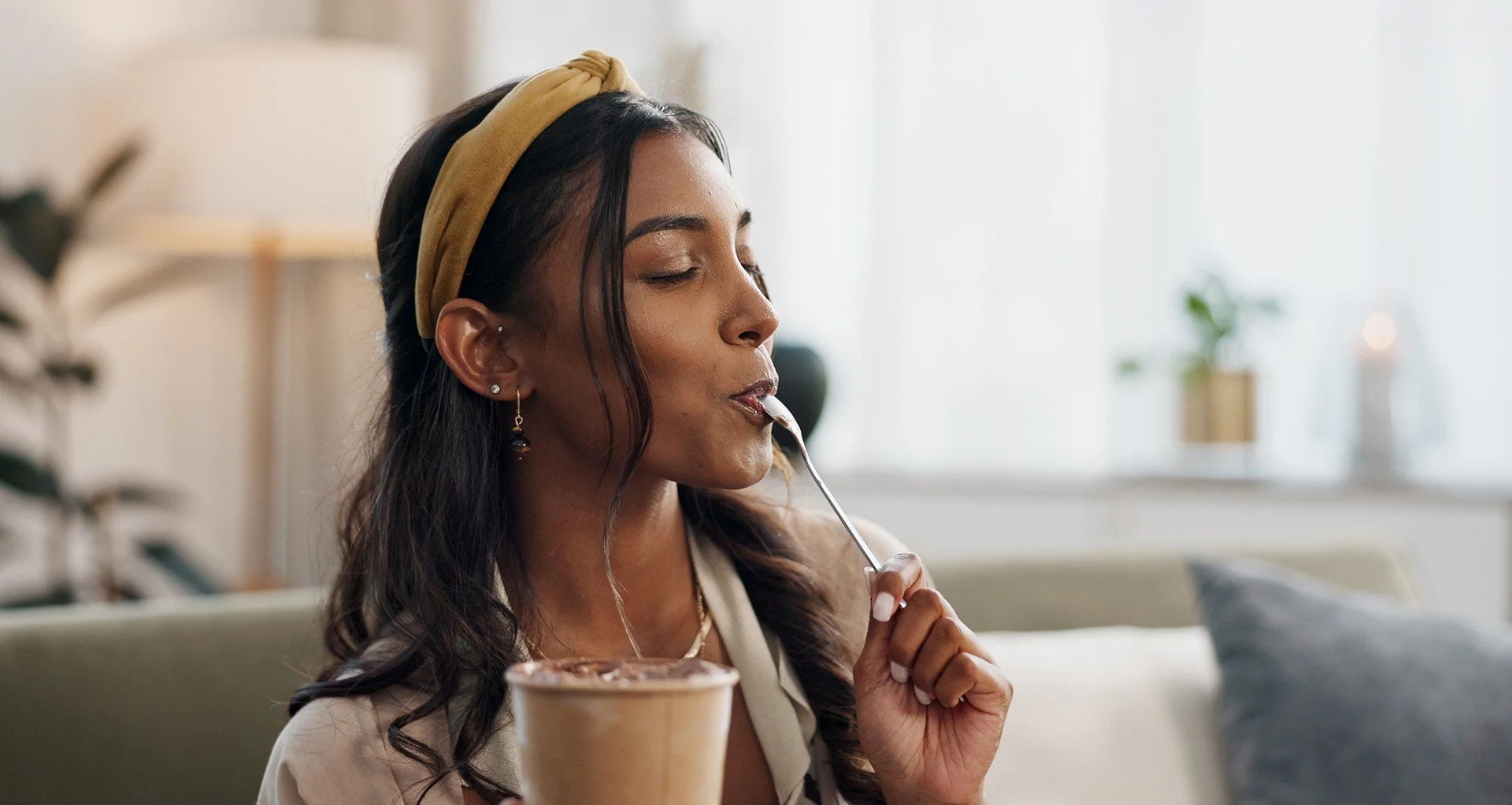 Woman savouring a dessert with eyes closed, symbolising mindful eating and sensory pleasure.