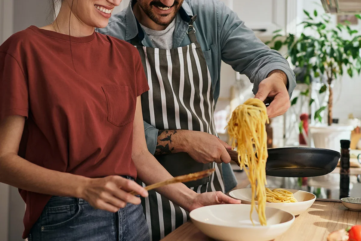 Couple cooking pasta together at home, illustrating how Customer journey research UK uncovers real-life consumer behaviours, emotional triggers, and decision-making moments that shape brand experiences.