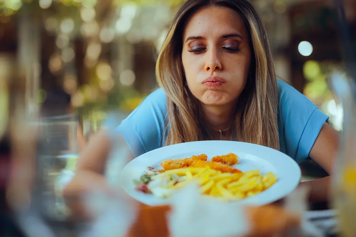 Unimpressed woman looking at her meal, representing how Consumer Closeness Research UK helps brands understand genuine consumer reactions, uncover frustrations, and solve key challenges through real-world behavioural insight.