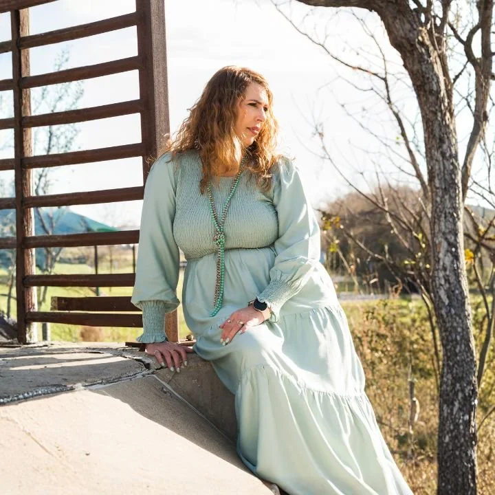 Faith-based counselor in Texas and Florida sitting near a bridge, looking thoughtful outdoors.