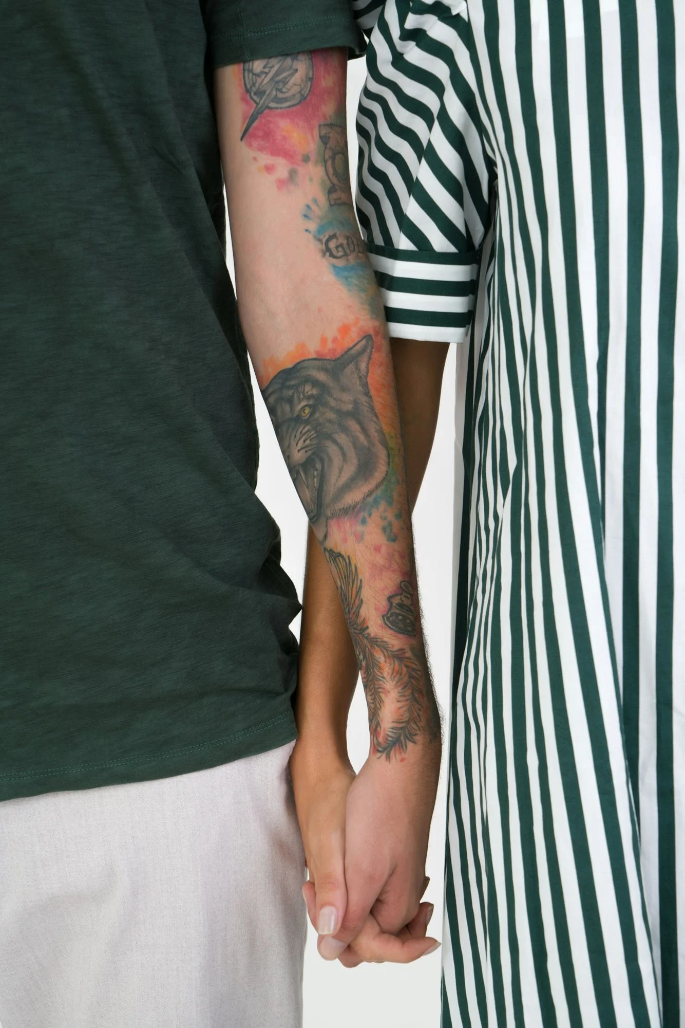 couple with tattoos holding hands