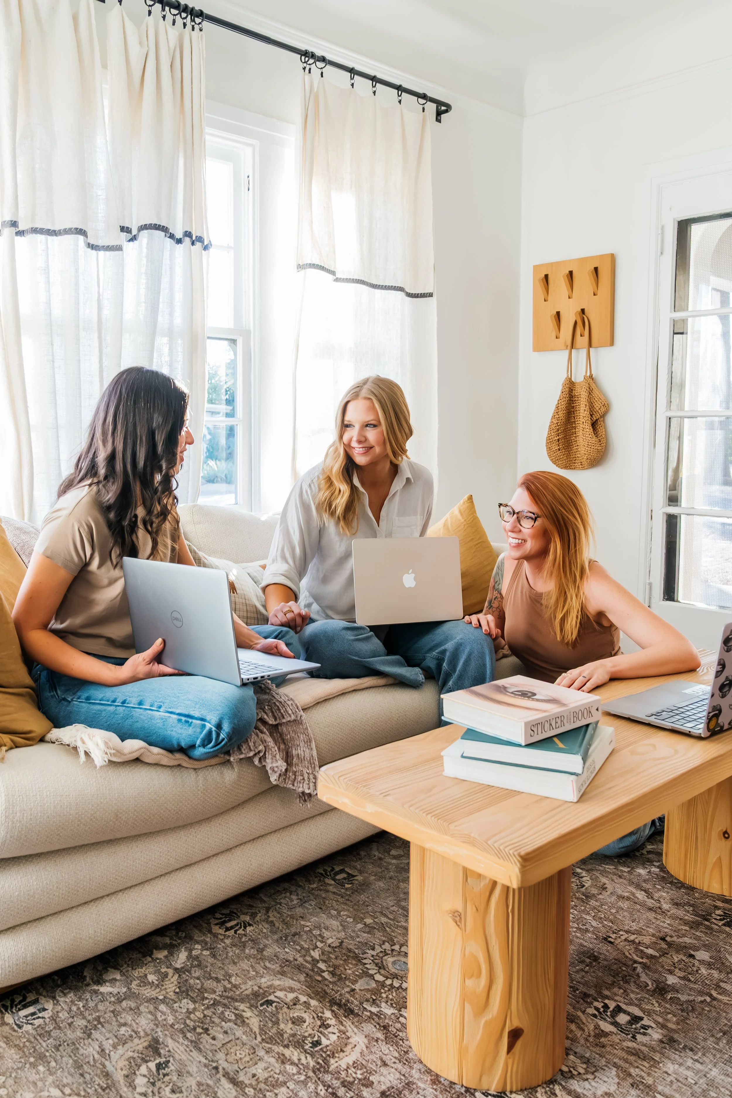 Winnie, Lily, and Tyler of REM Real Estate Marketing working through a client's content management in a living room