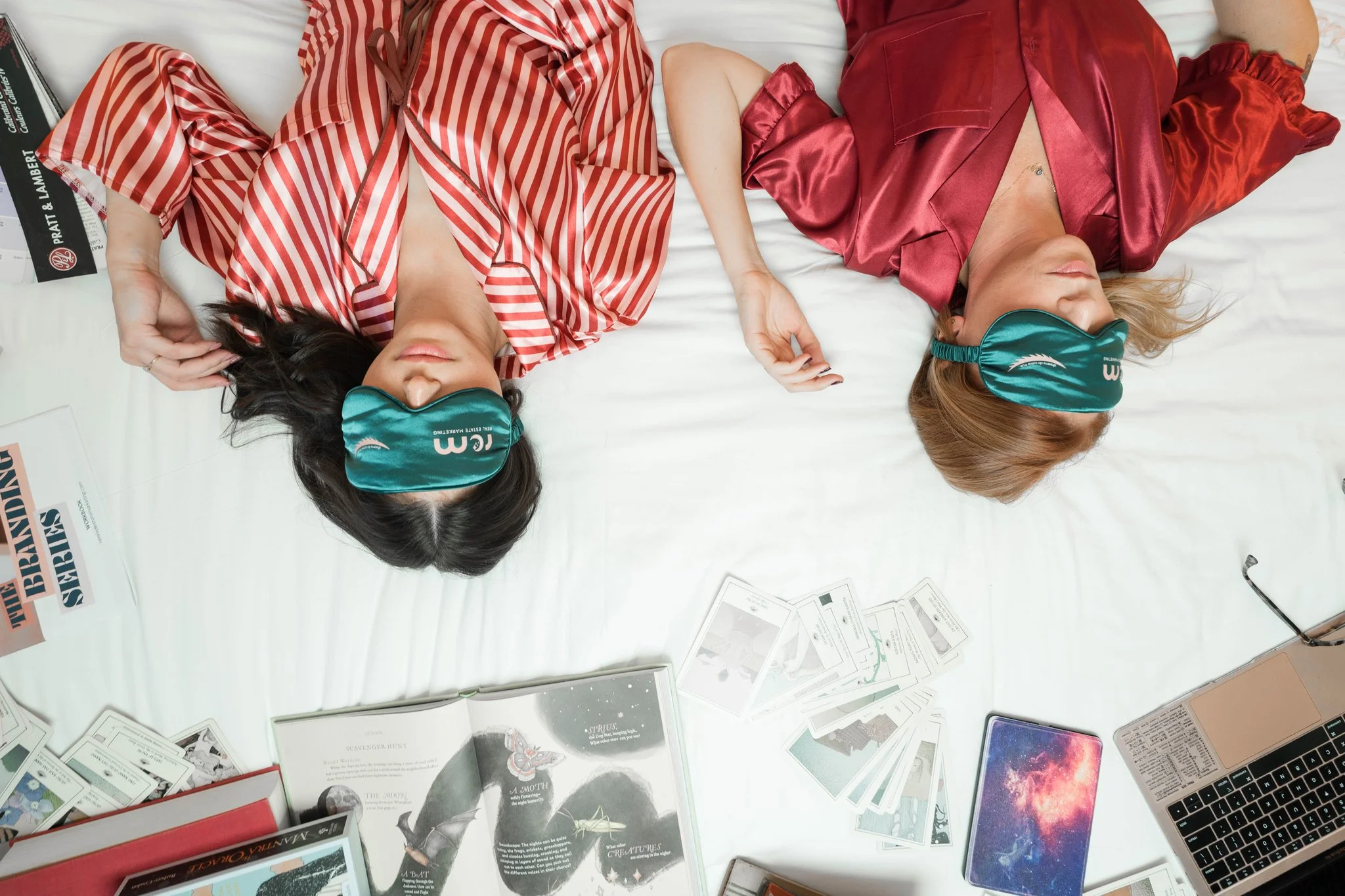 Winnie Rodgers and Tyler Miller of REM Real Estate Marketing lying on a bed wearing sleep masks, resting up before an Alignment Call
