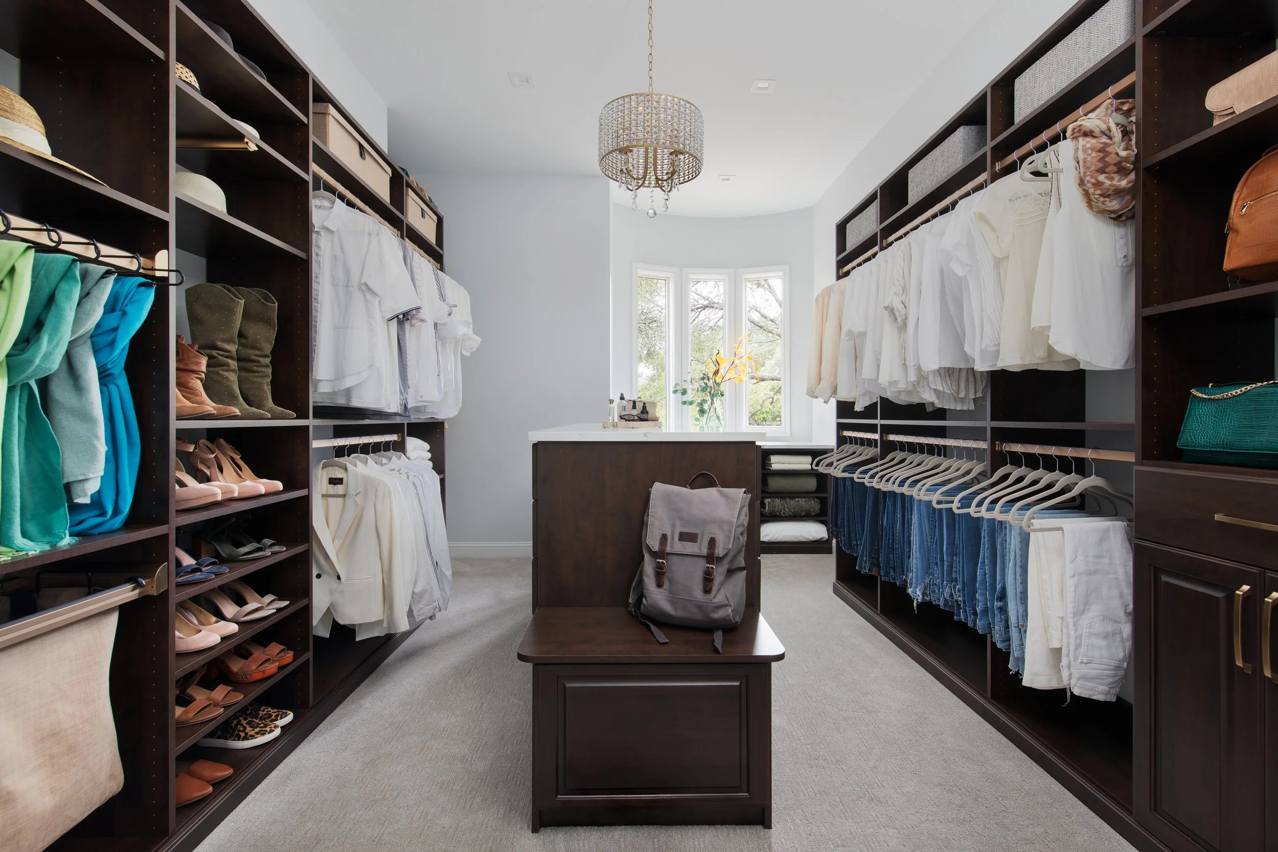 custom walk in closet with seating and chandelier.jpg