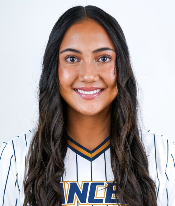 Young woman with long dark hair smiling, wearing a white sports jersey with blue and yellow accents.